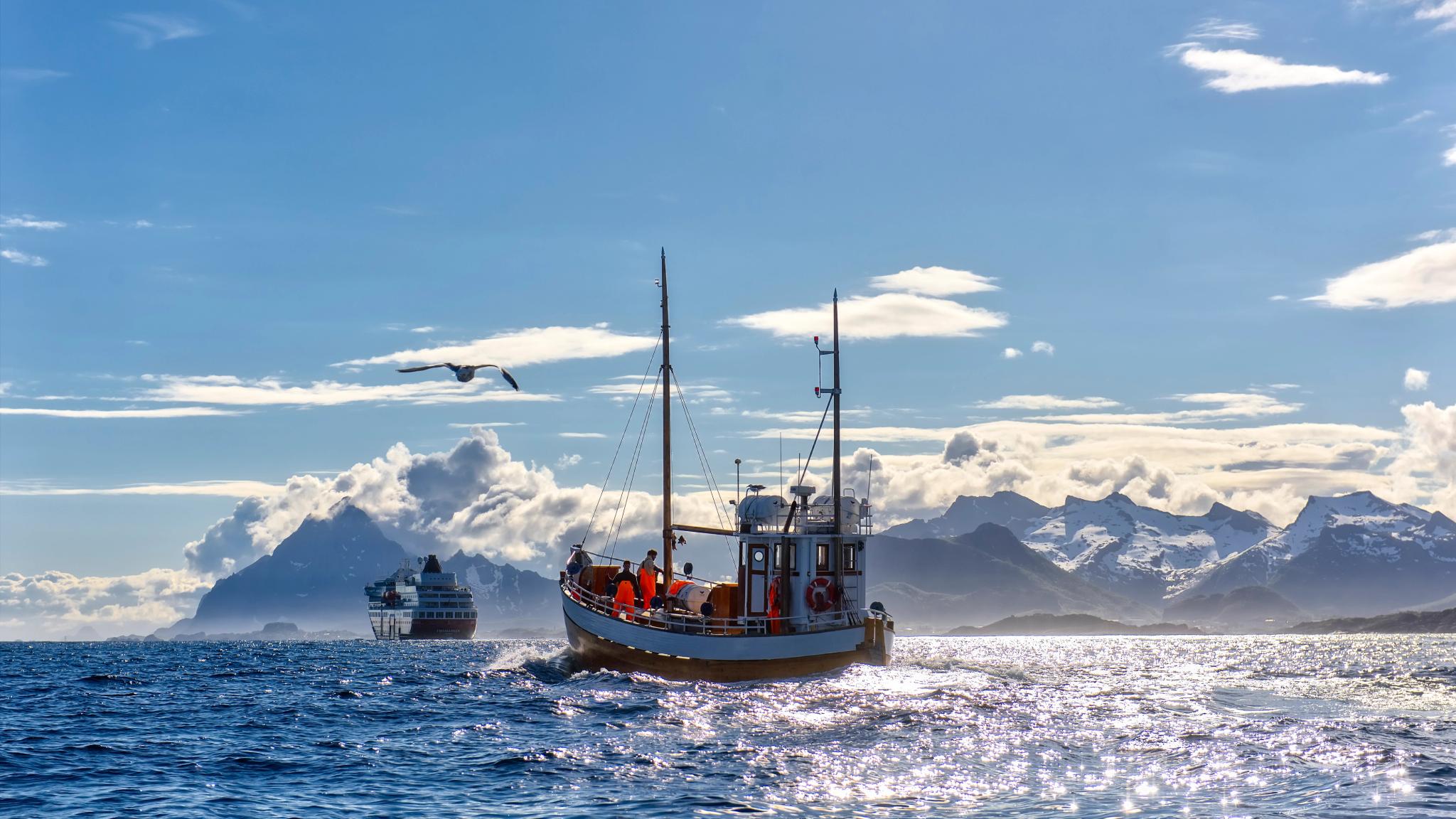 A fishing boat in front of a Hurtigruten ship in Northern Norway