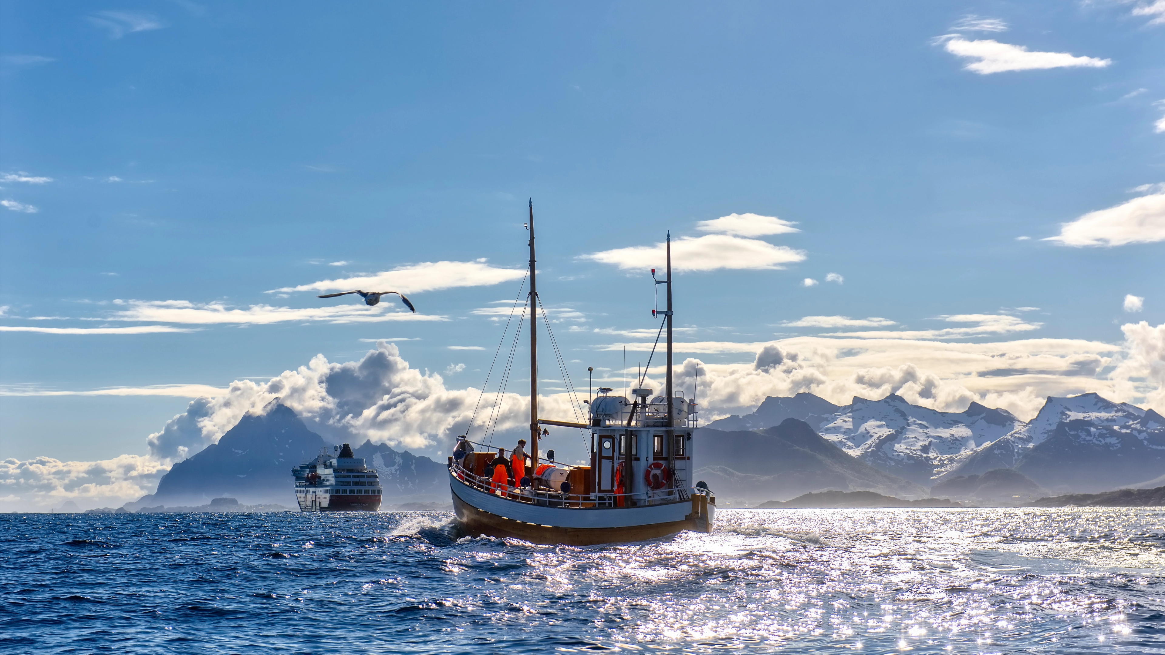 A fishing boat in front of a Hurtigruten ship in Northern Norway