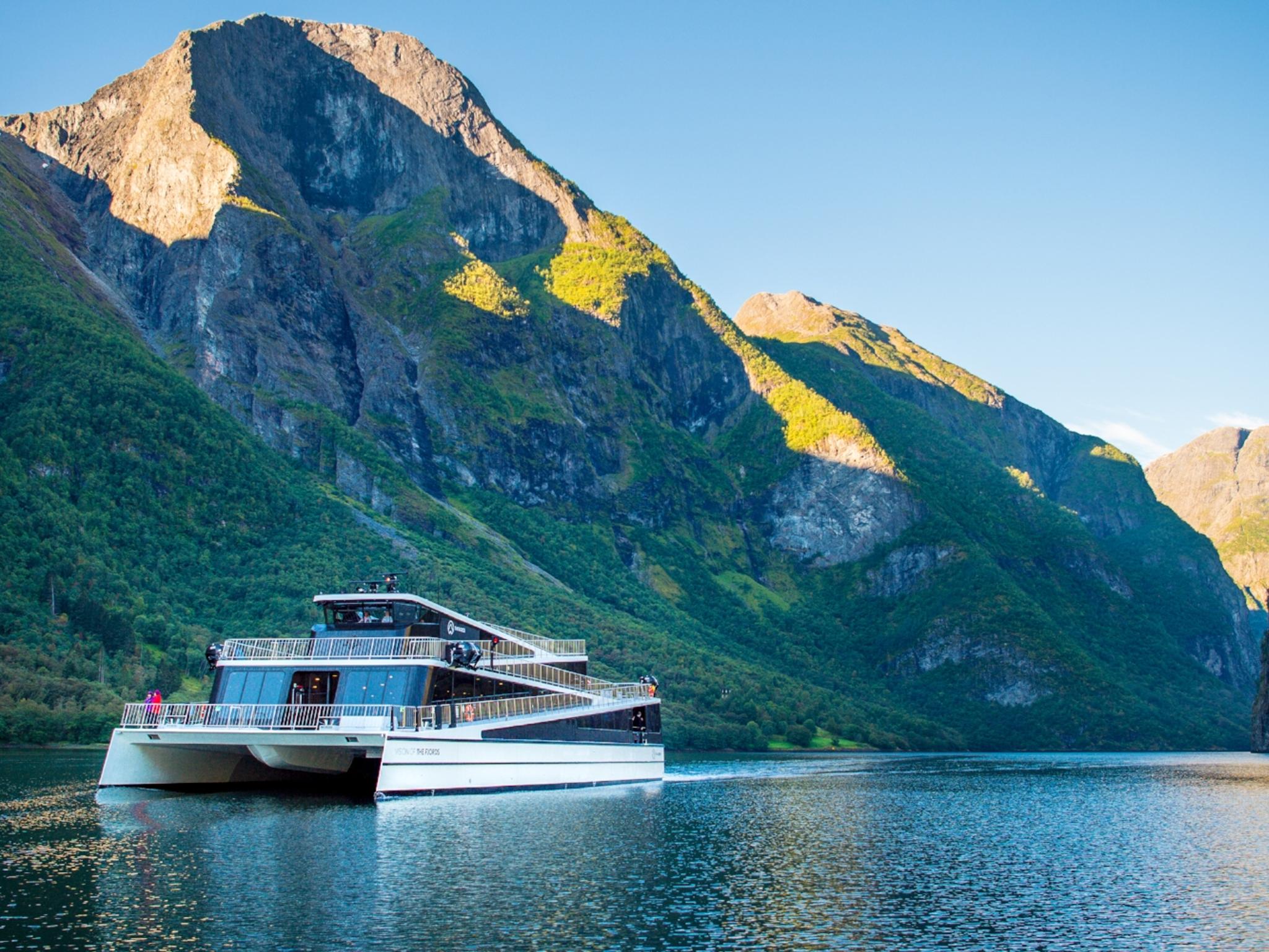 The hybrid electric vessel Vision of the Fjords cruising the Aurlandsfjorden fjord surrounded by mountains