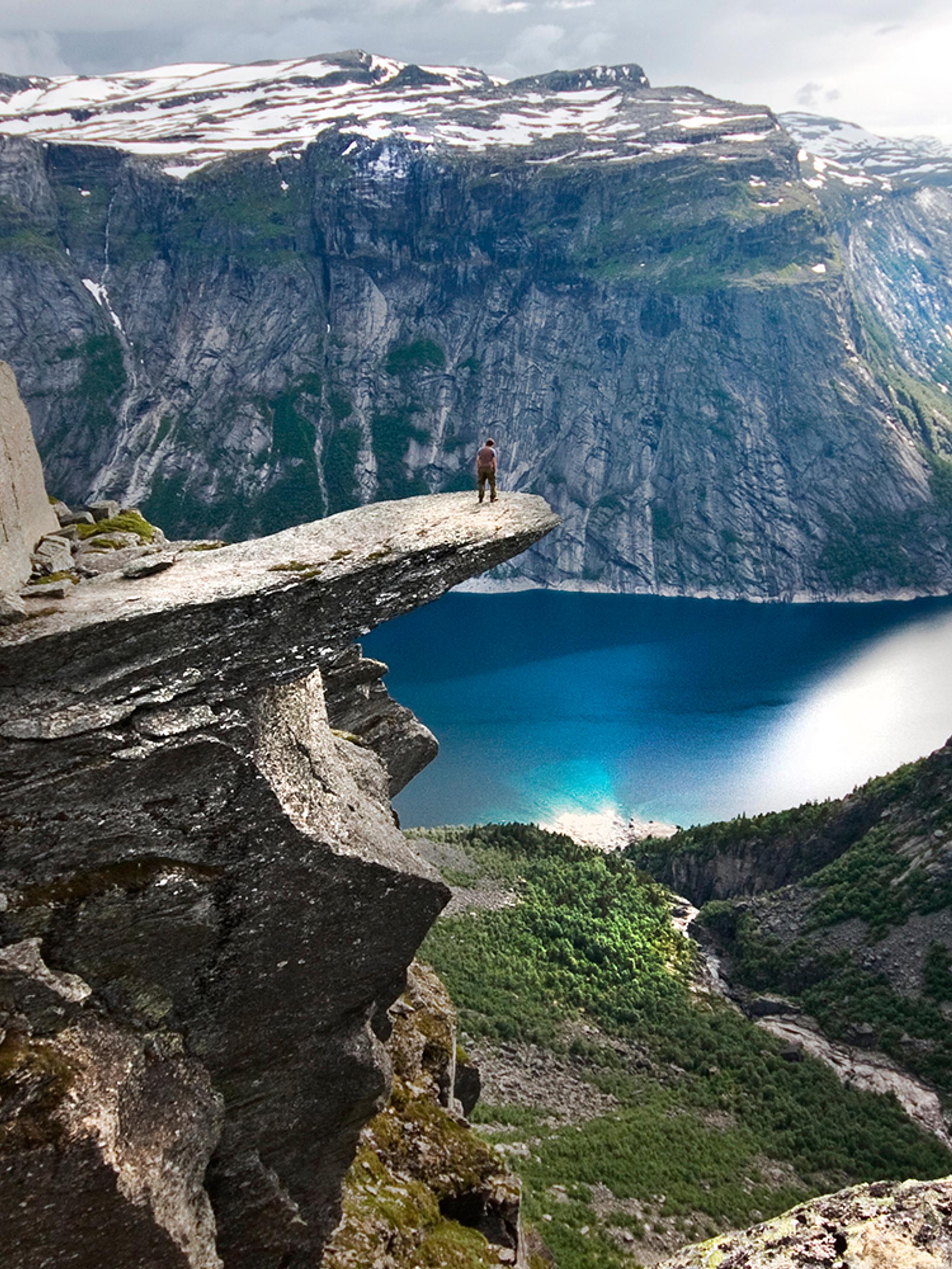 A person on the mountain plateau Trolltunga above Lake Ringedalsvatnet in the Hardangerfjord region, Fjord Norway