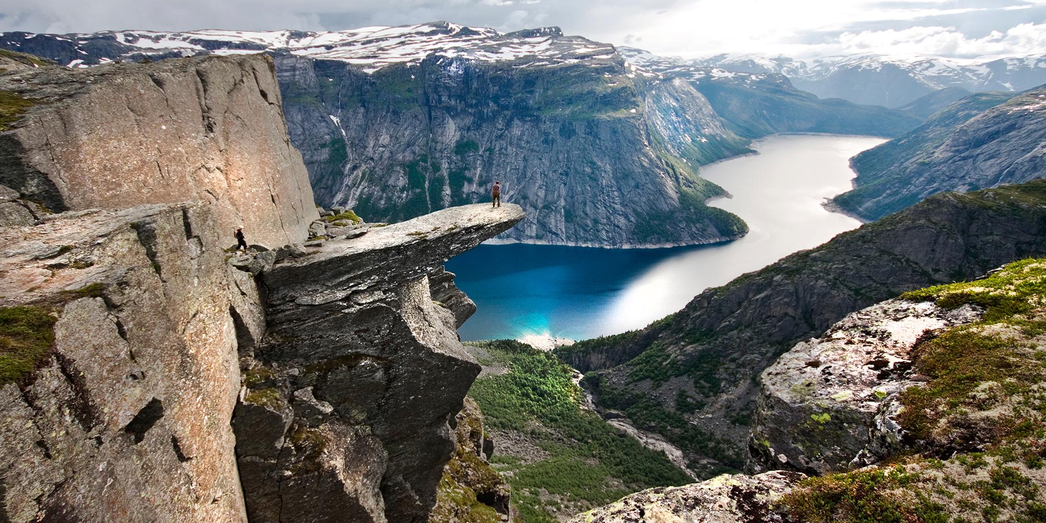 Escursionista sull’altopiano di Trolltunga sopra il lago Ringedalsvatnet nella regione di Hardangerfjord, Norvegia dei fiordi