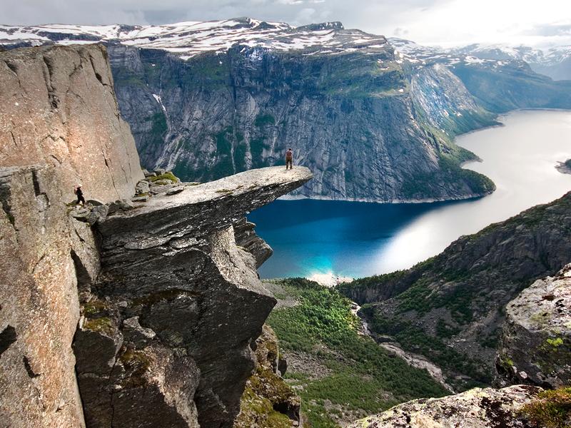 Una persona admira las vistas del lago Ringedalsvatnet desde lo alto de la famosa formación Trolltunga, en Hardanger, la Noruega de los fiordos.