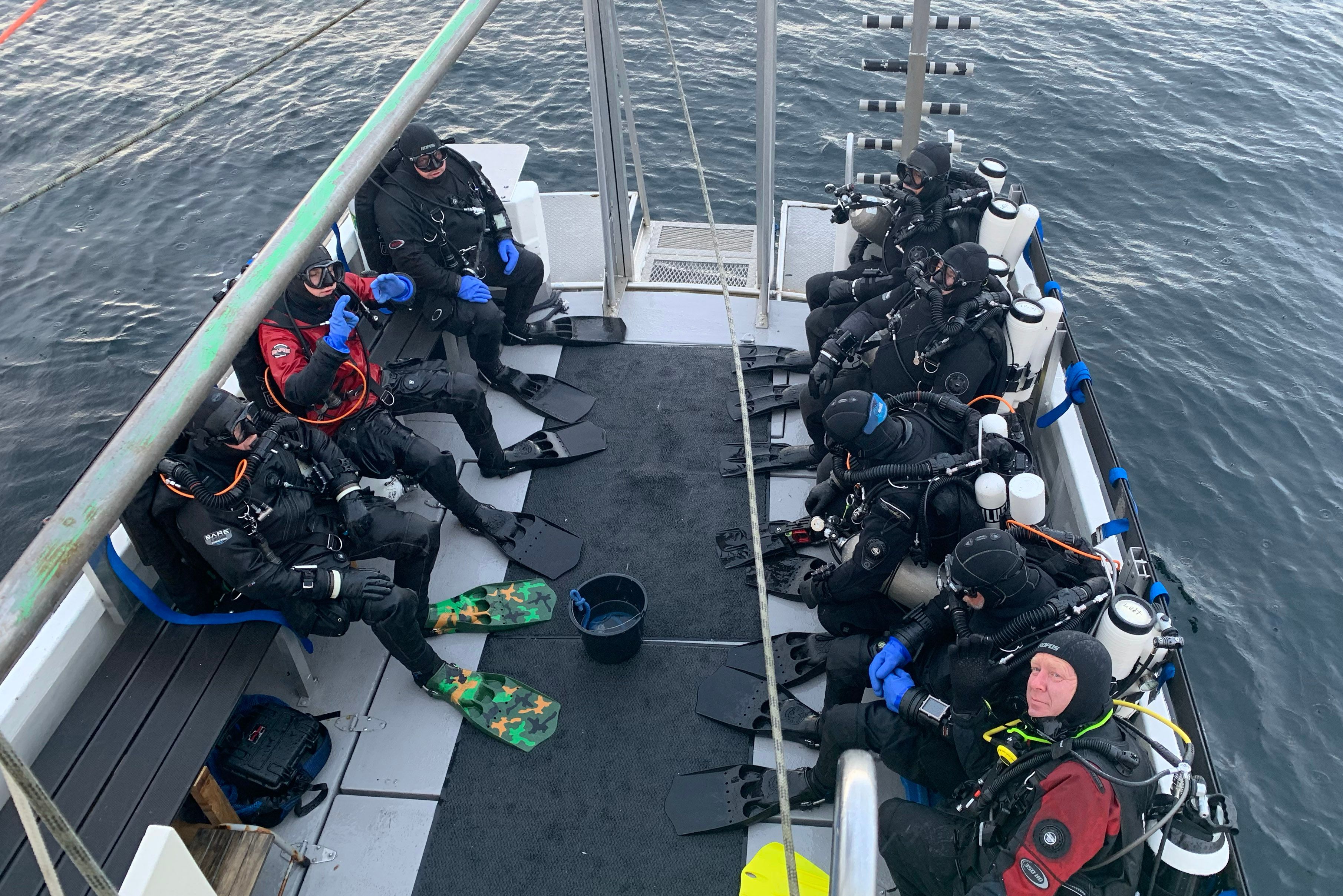 People in scuba dive suites ready to scuba dive from a boat in Southern Norway