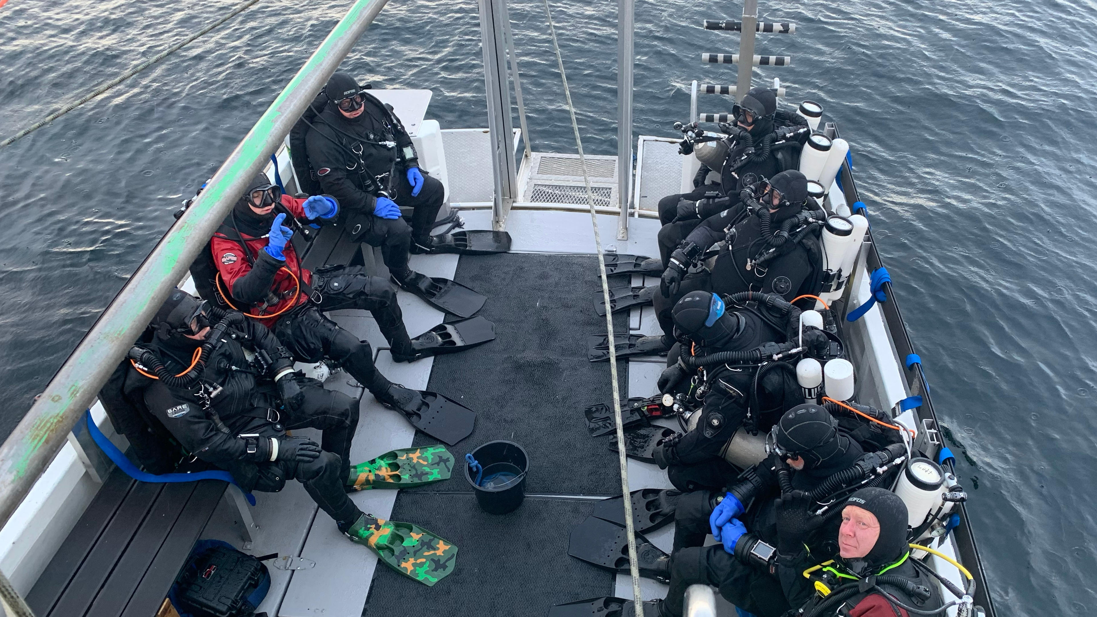 People in scuba dive suites ready to scuba dive from a boat in Southern Norway