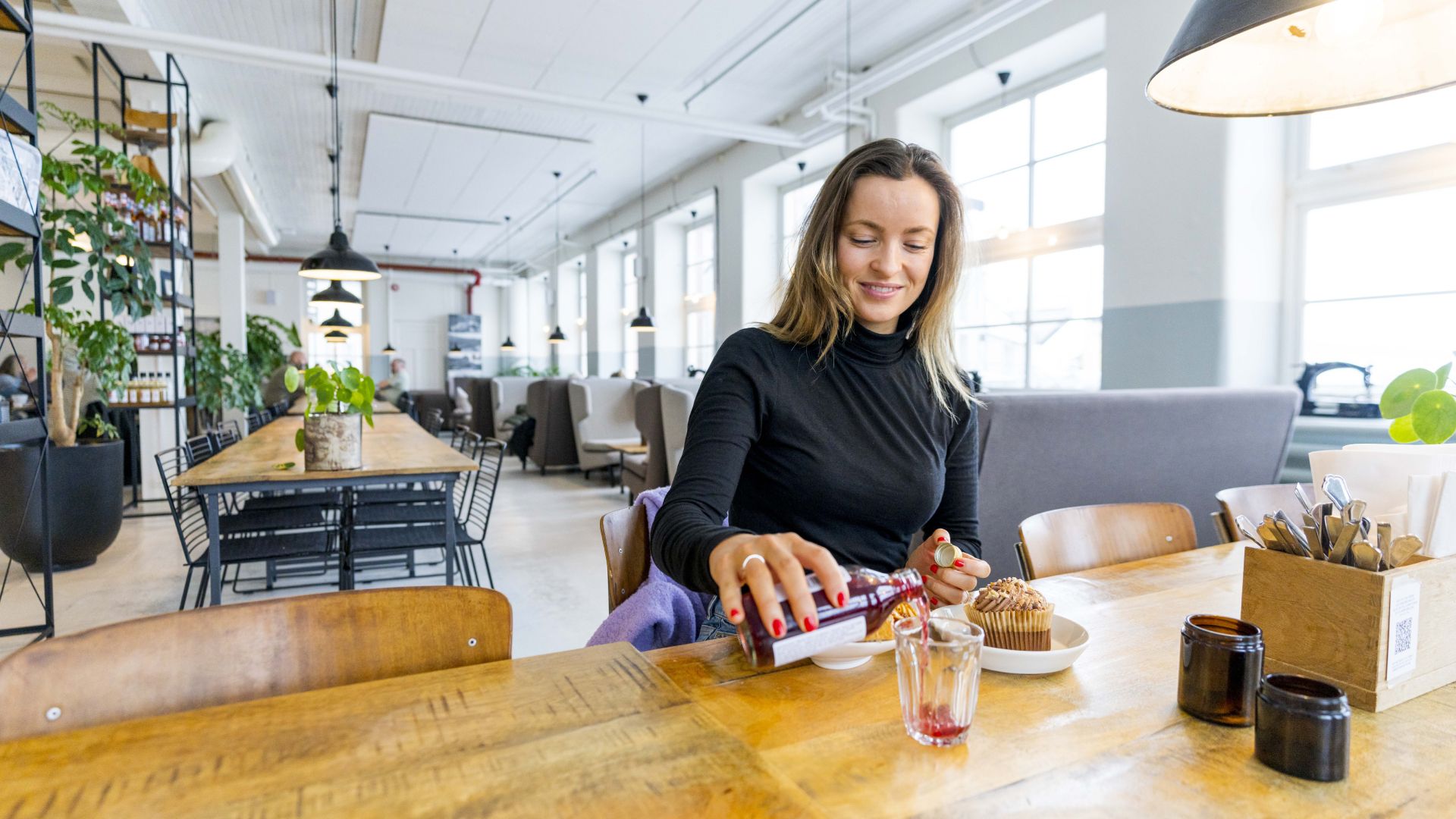 Woman having lunch on the cafe at Devoldfabrikken, in Langevåg