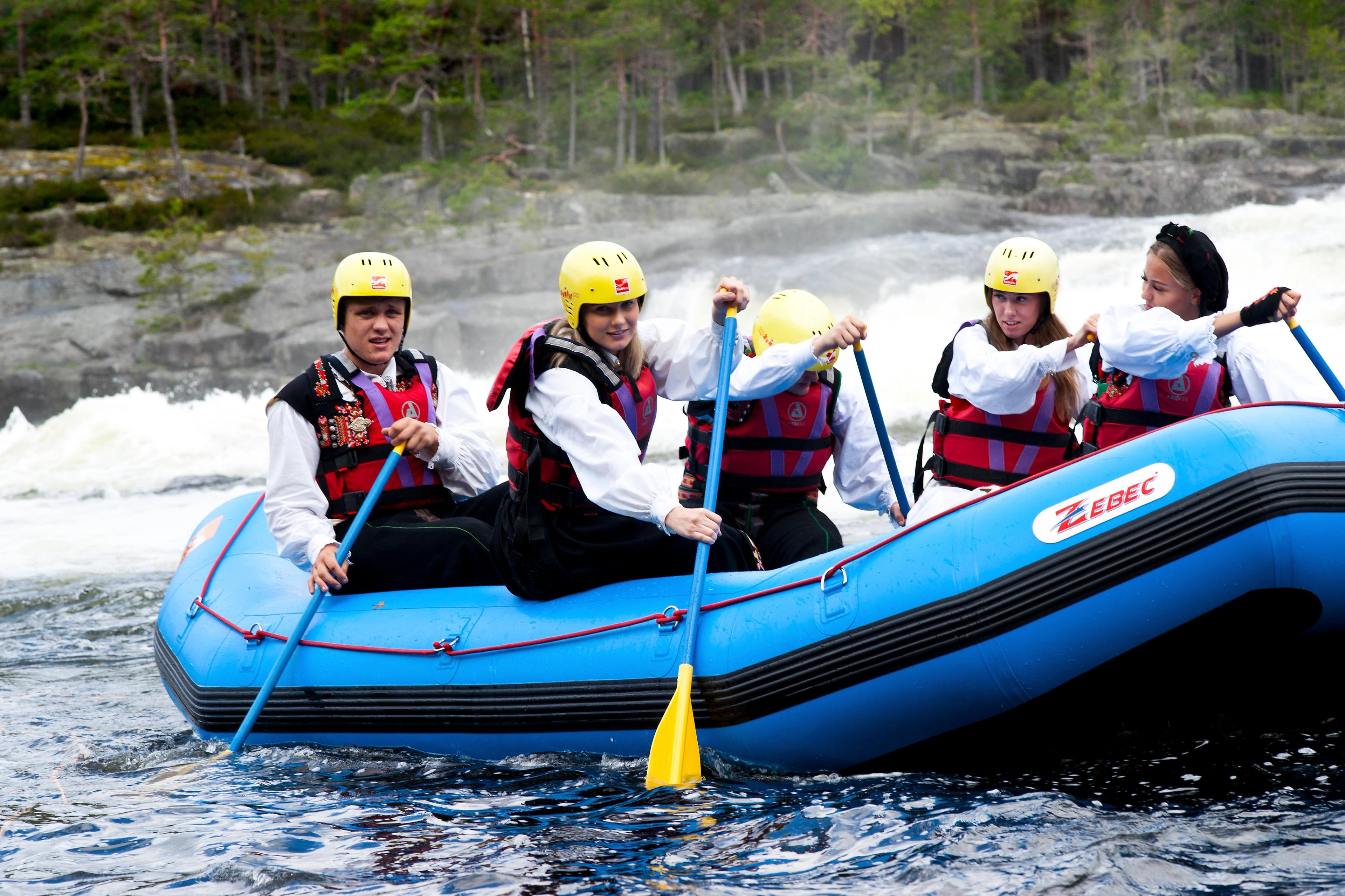 A group of young people rafting in national costumes on the Otra river in Setesdal, Southern Norway