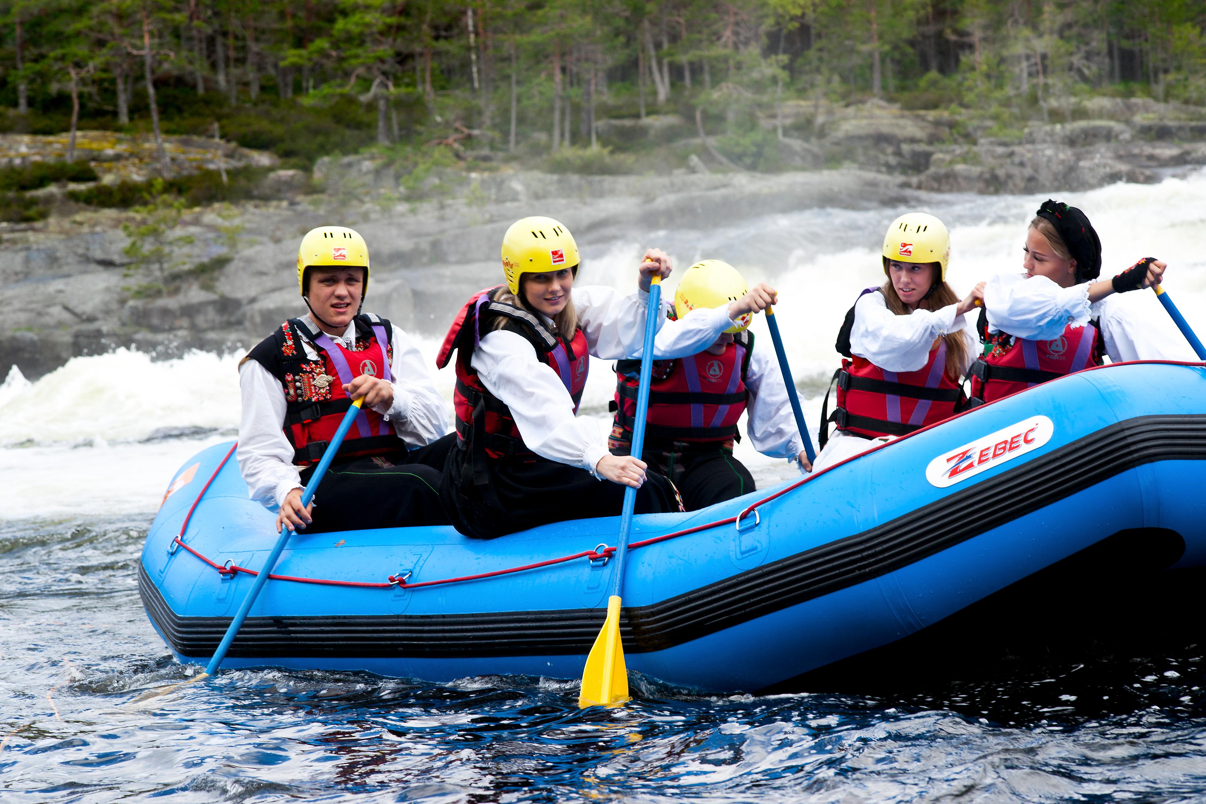 A group of young people rafting in national costumes on the Otra river in Setesdal, Southern Norway