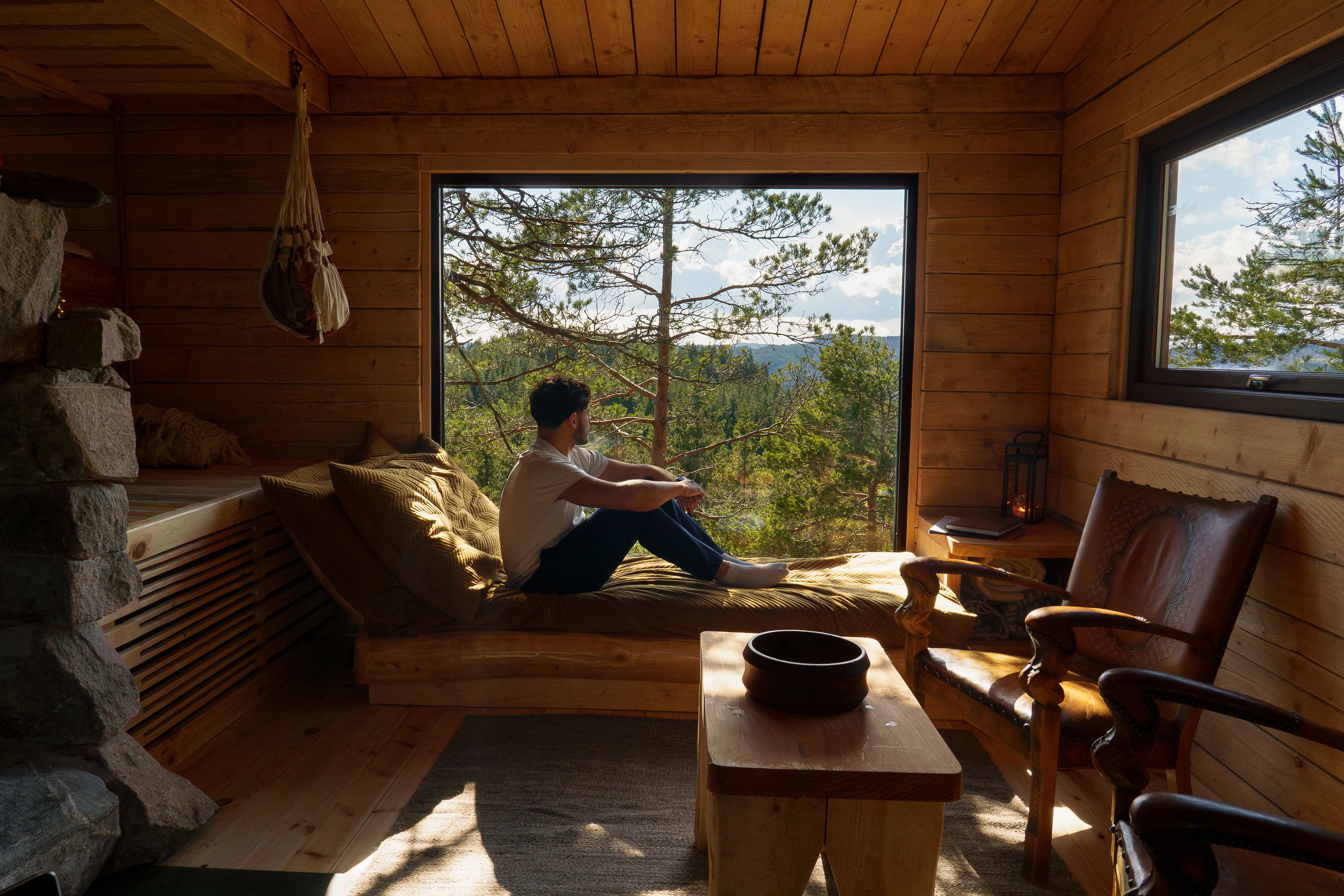 A man sitting in the window at TreeTop Fiddan cabin