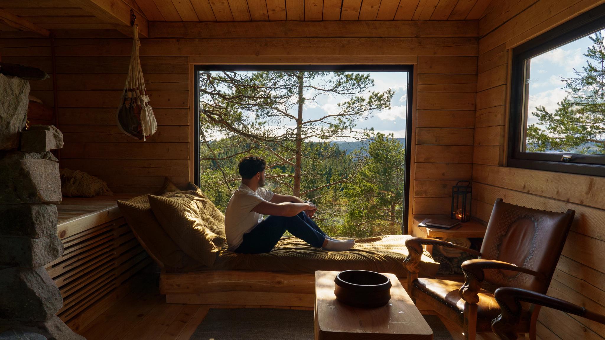 A man sitting in the window at TreeTop Fiddan cabin
