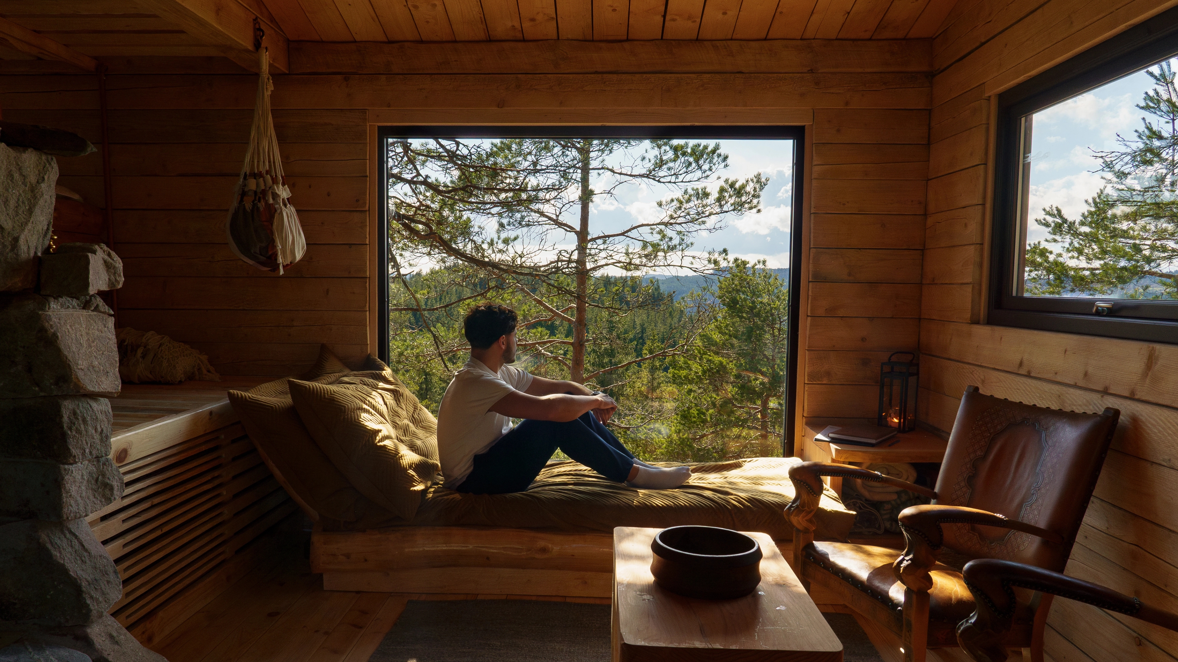 A man sitting in the window at TreeTop Fiddan cabin