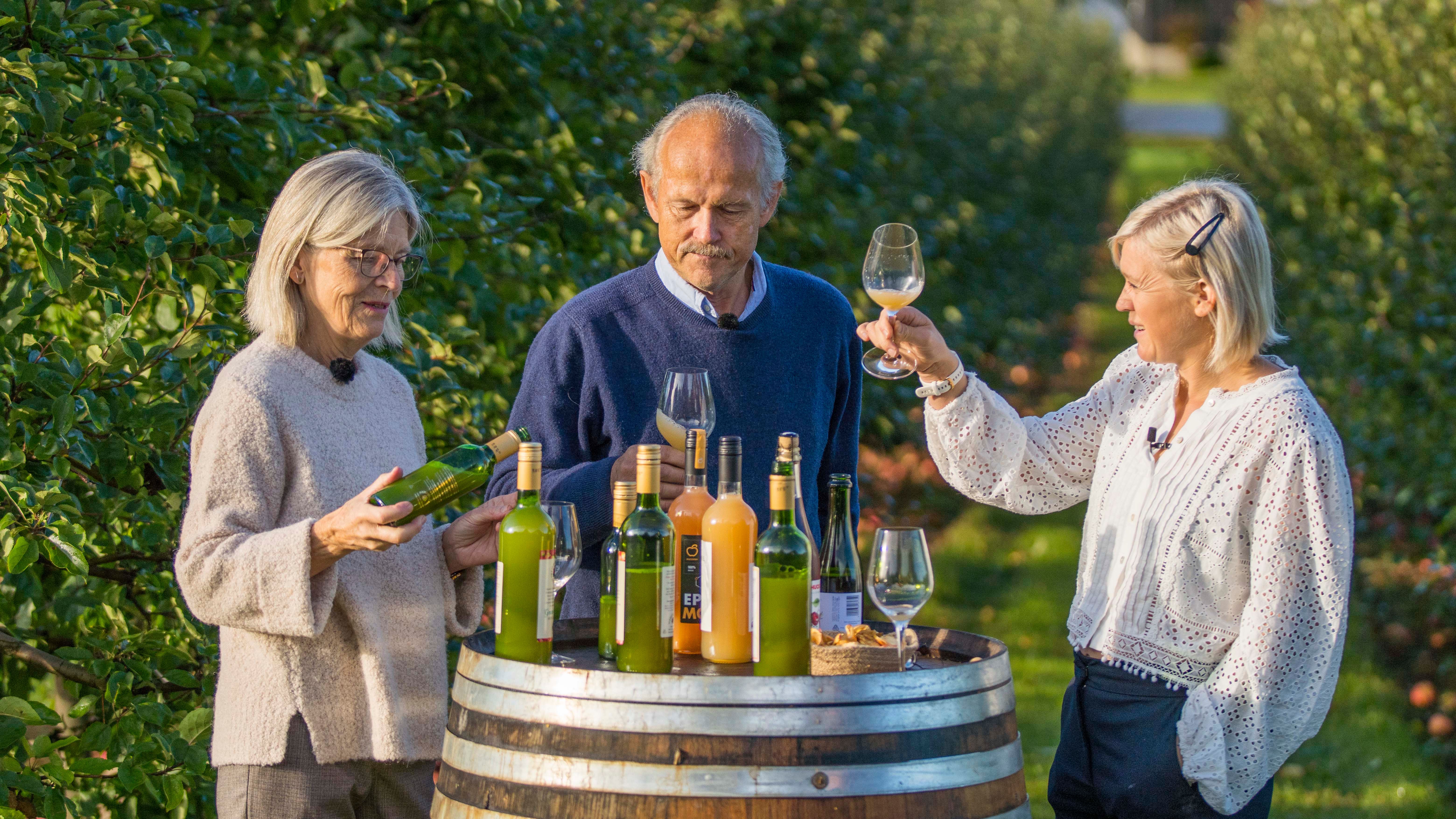Three people tasting apple juice made of Aroma apples in the Fruit Village