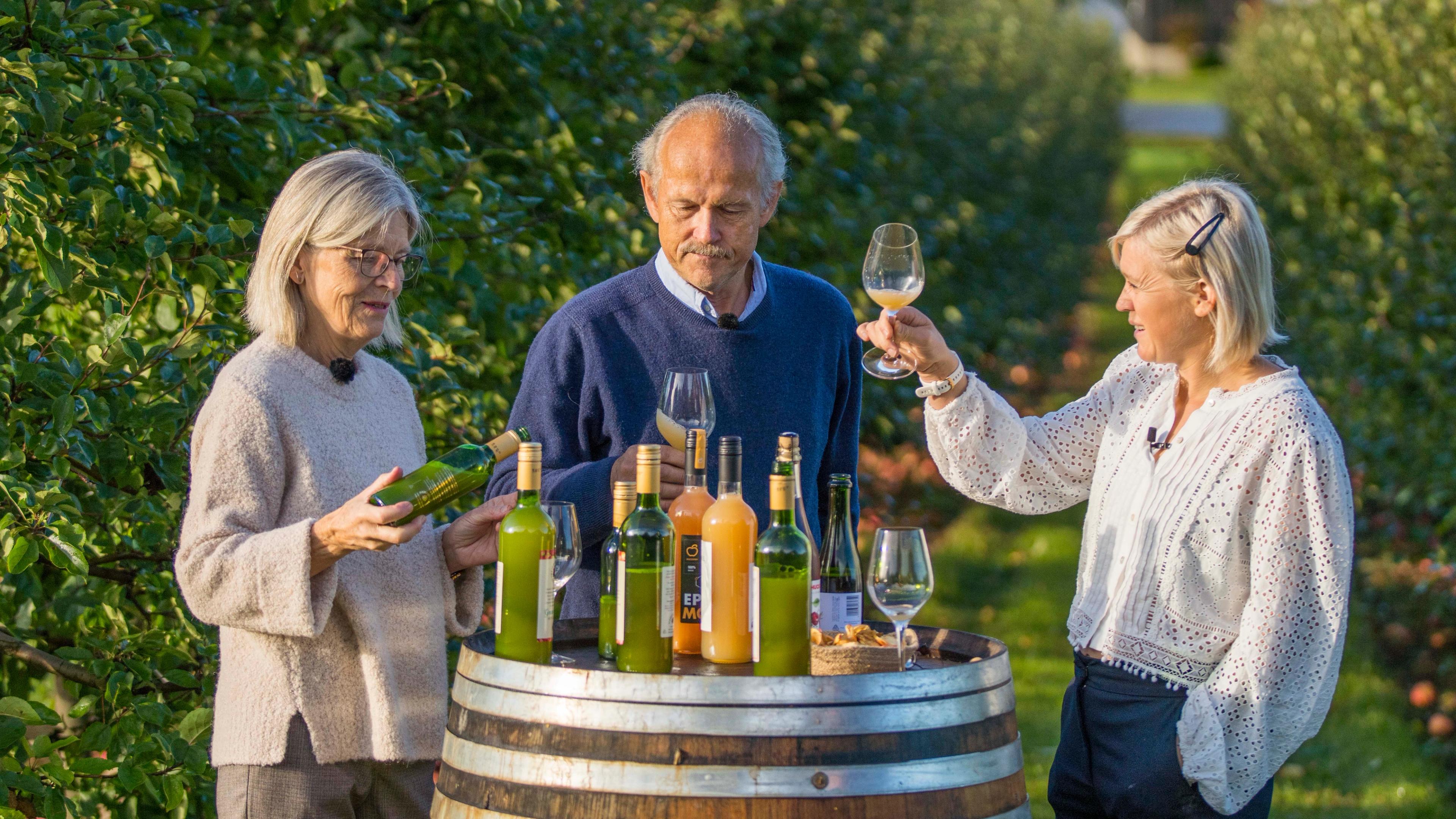 Three people tasting apple juice made of Aroma apples in the Fruit Village