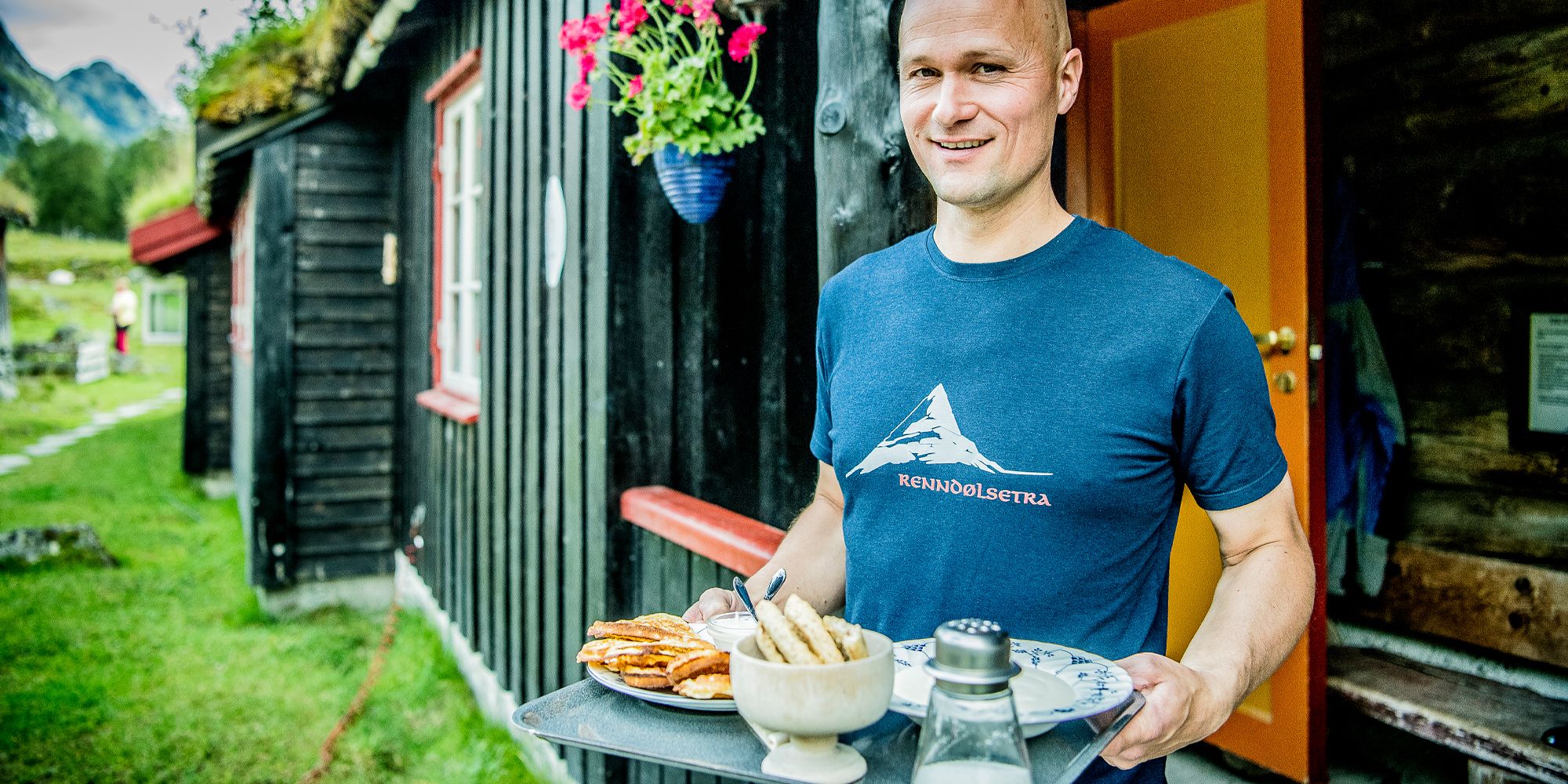 A man serving waffles at Renndølsetra in the Innerdalen valley in Northwest, Fjord Norway.
