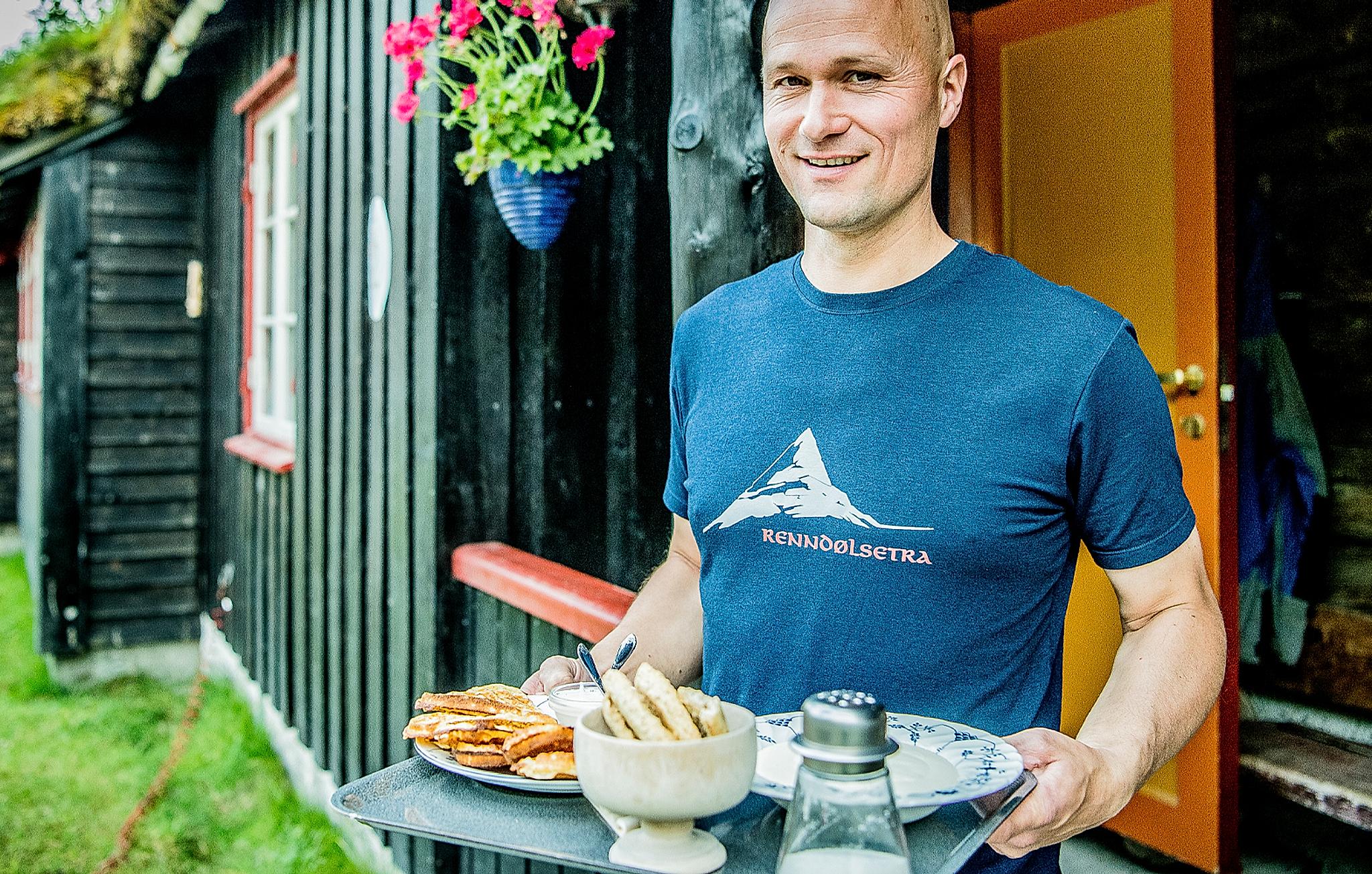 A man serving waffles at Renndølsetra in the Innerdalen valley in Northwest, Fjord Norway.