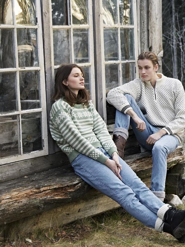 Two girls sitting on a bench outside, wearing woollen pullovers