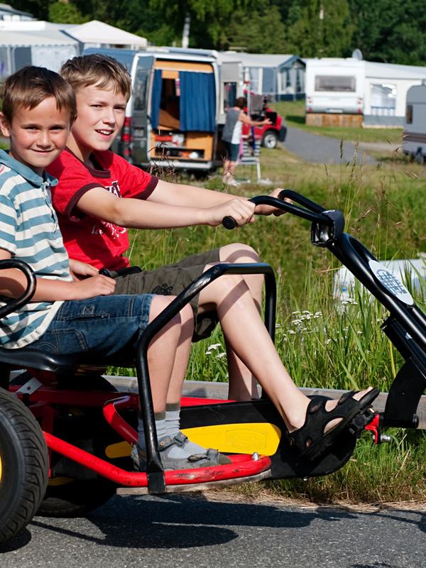 To gutter sitter på en tråbil på Sørlandet feriesenter