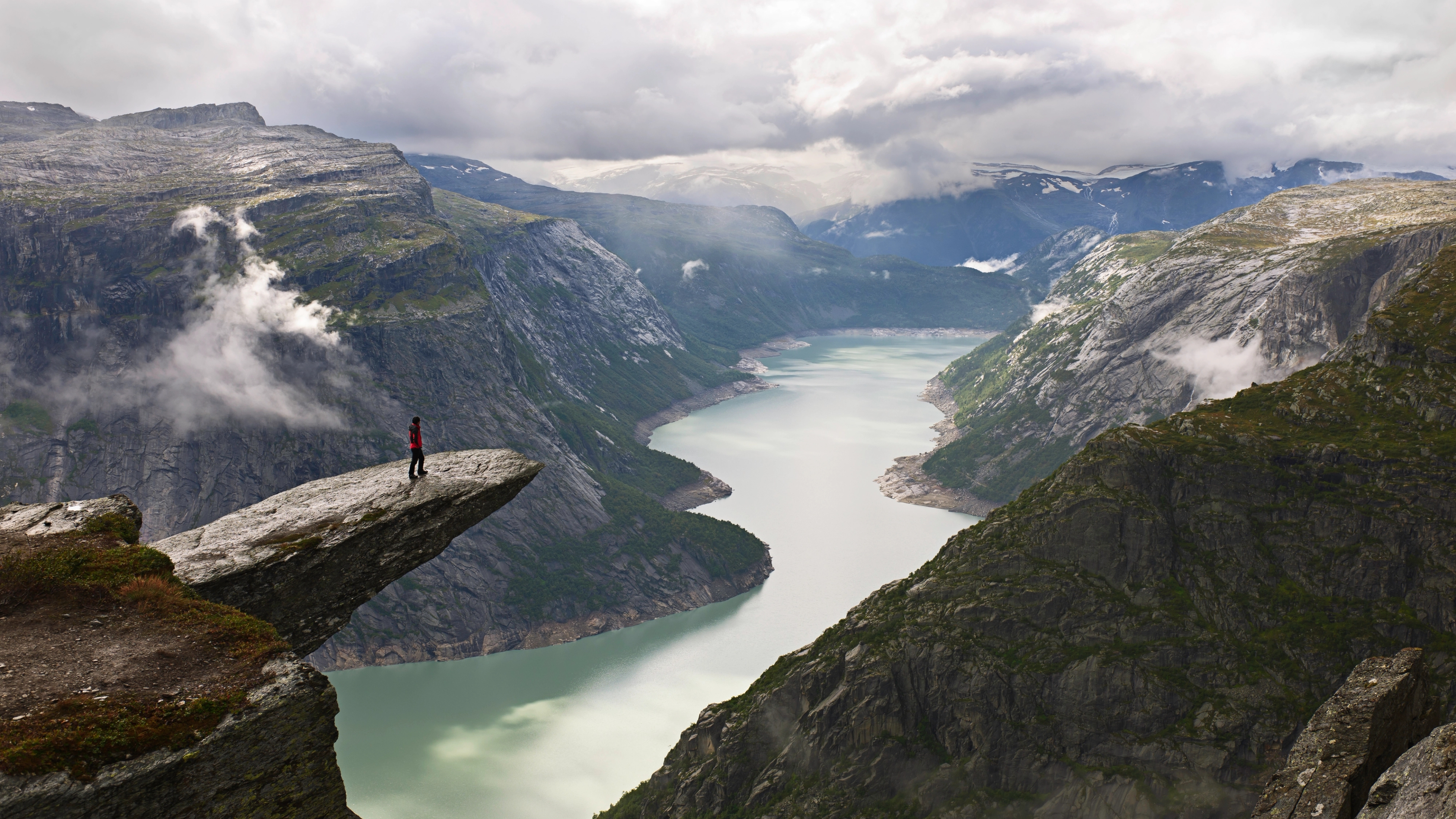 A person on the mountain plateau Trolltunga above Lake Ringedalsvatnet in the Hardangerfjord region, Fjord Norway
