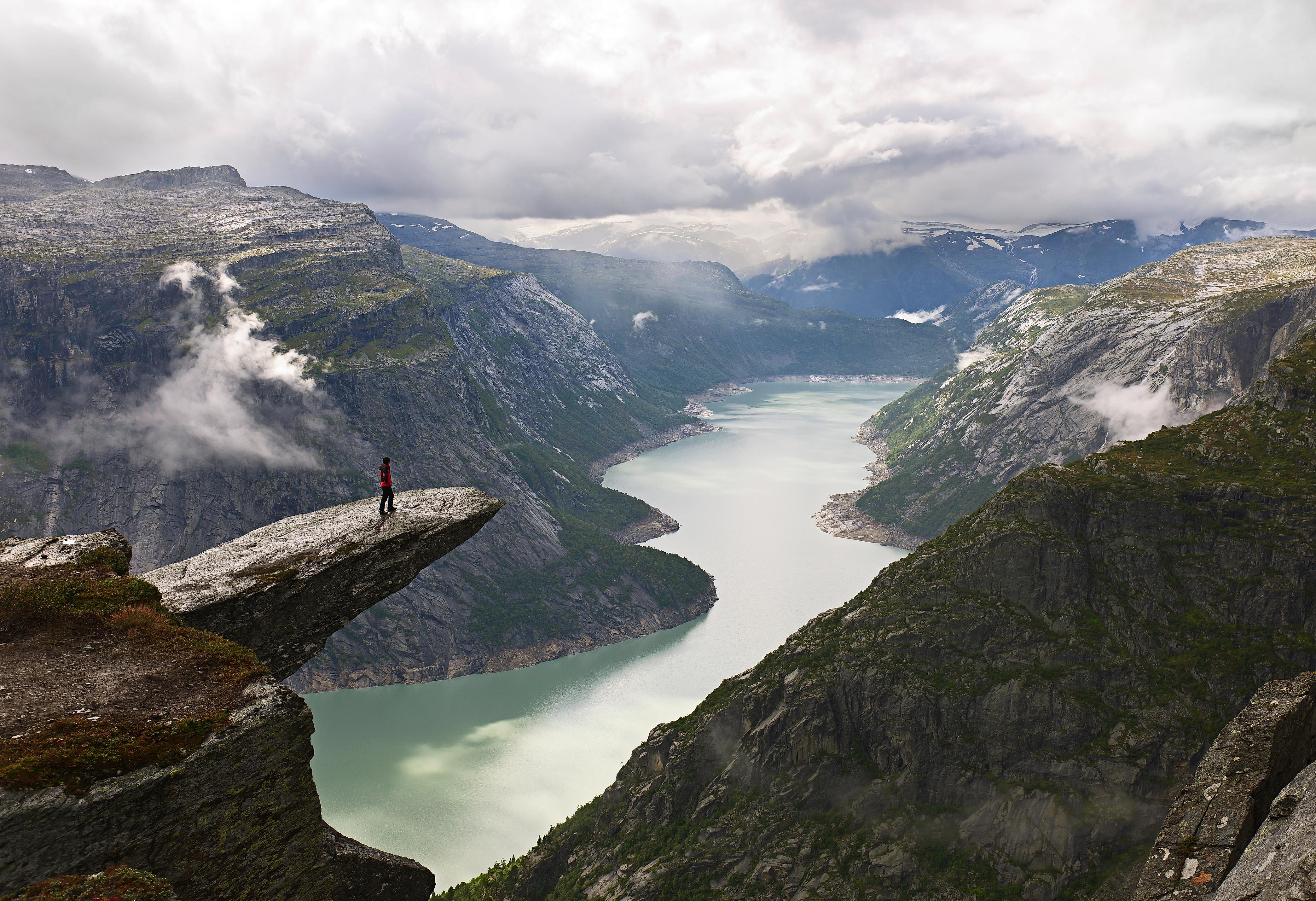 A person on the mountain plateau Trolltunga above Lake Ringedalsvatnet in the Hardangerfjord region, Fjord Norway