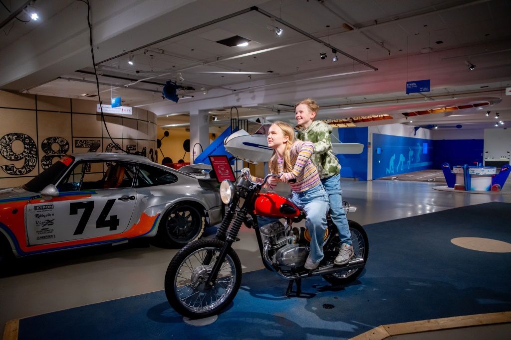 To barn på en motorsykkel i et museum.