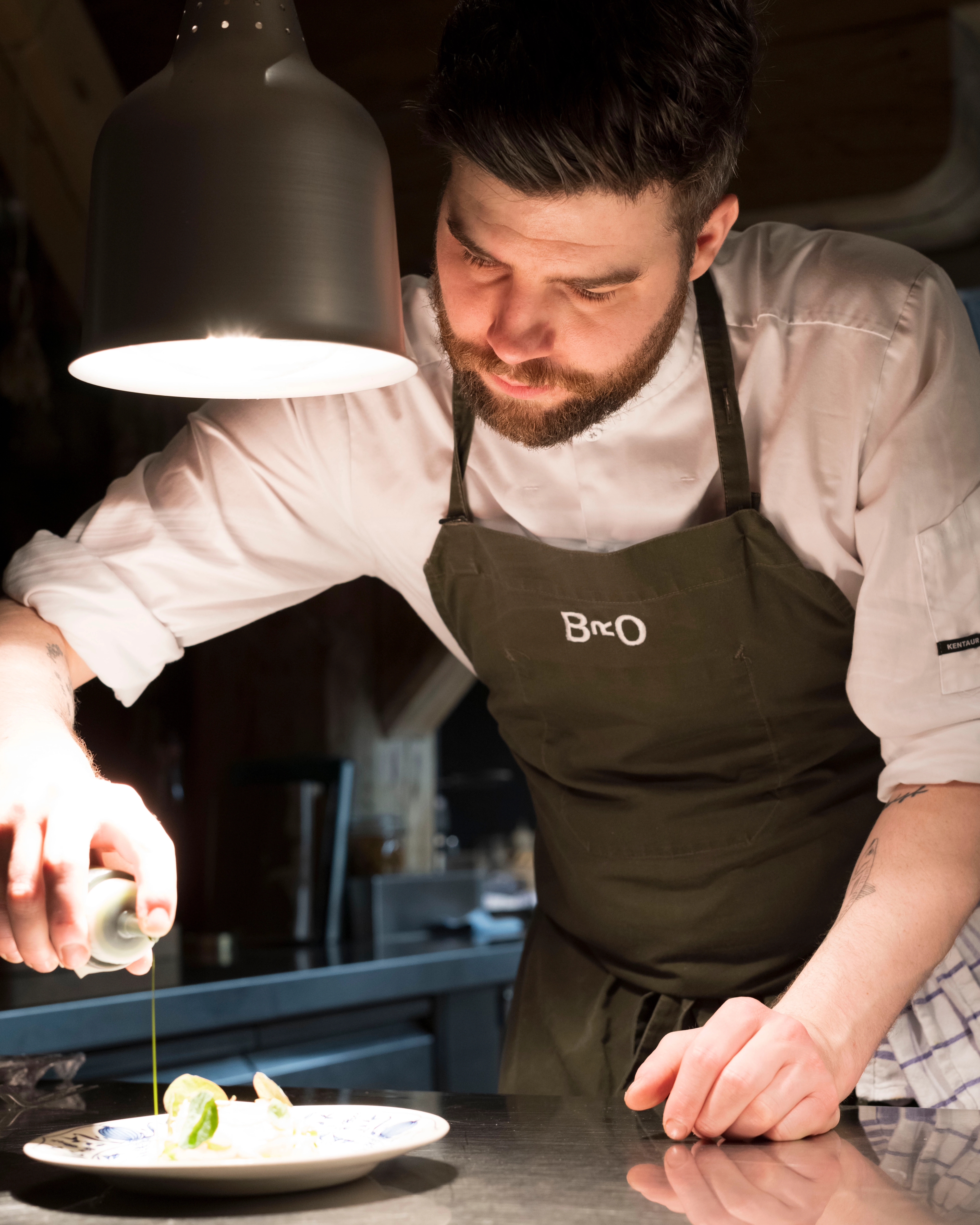 Chef Skyler Milner preparing dish at Bro restaurant in Ålesund