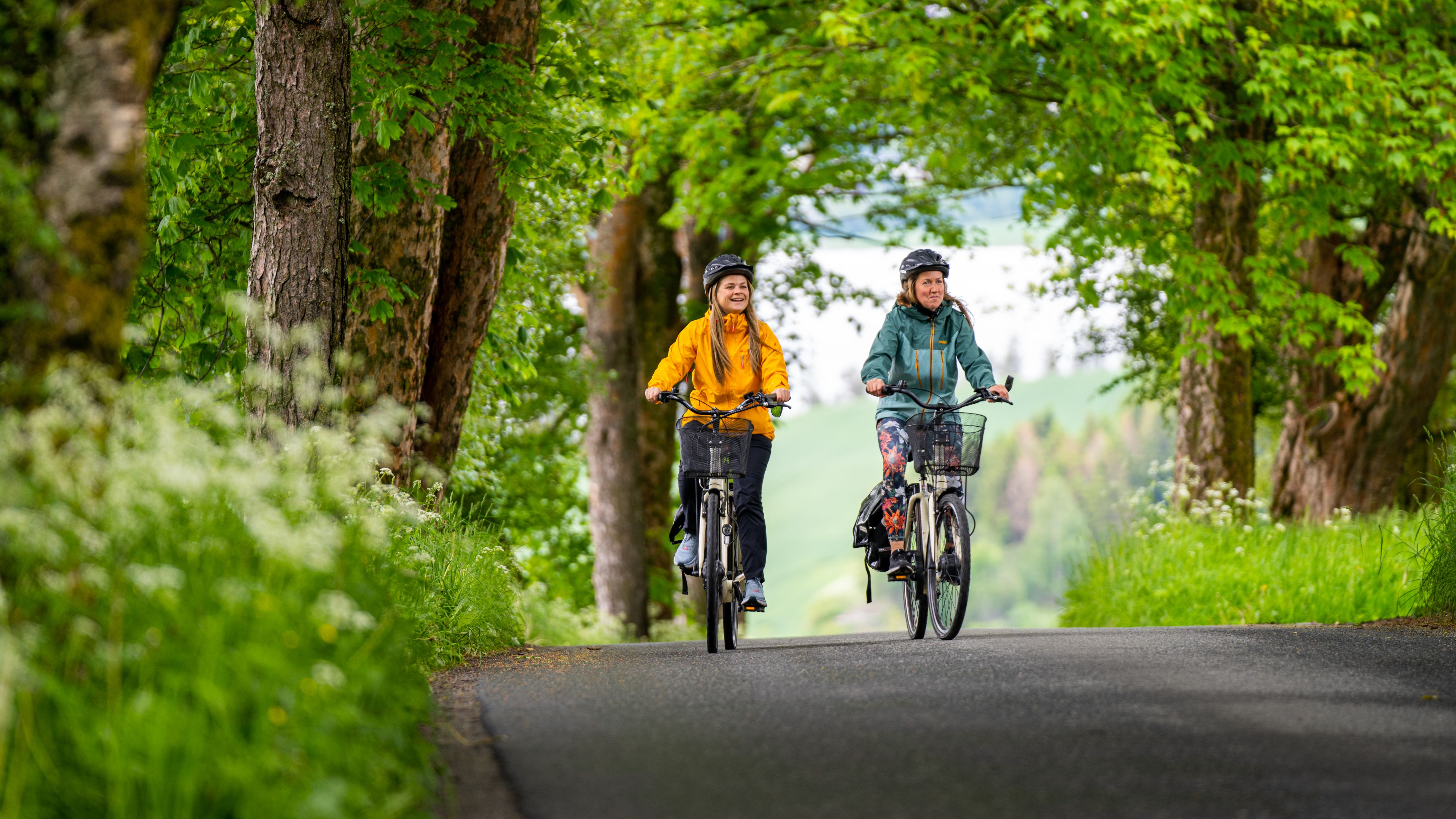 Two woman cycling among flowerfields at The Golden Road, Inderøy