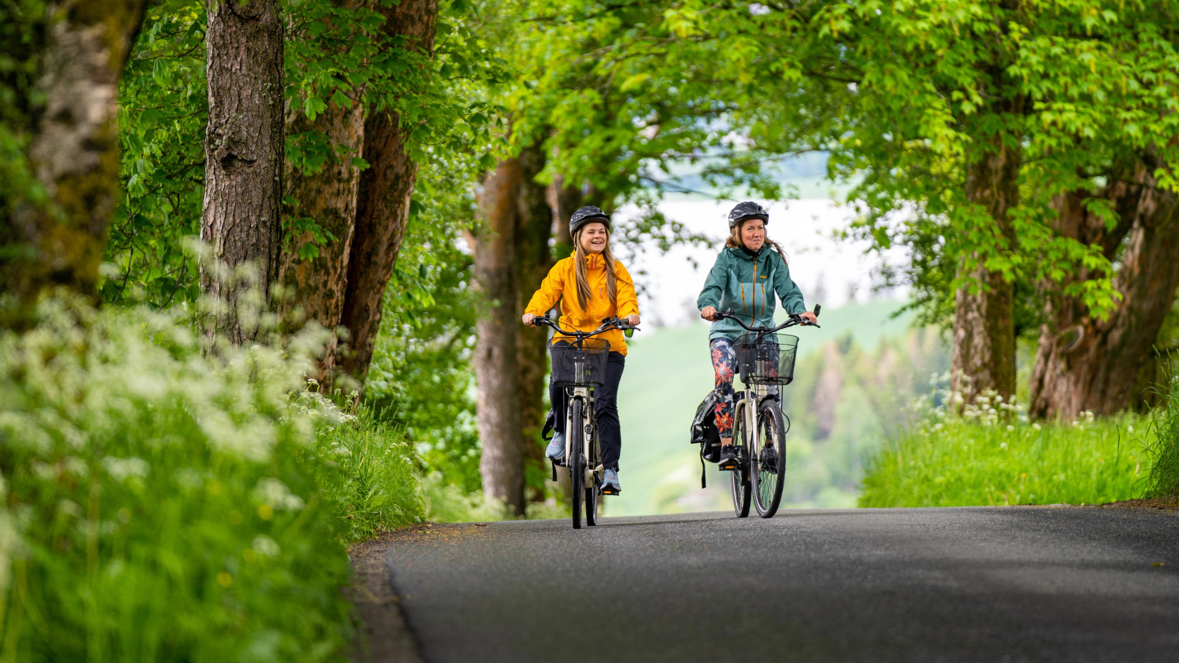 Two woman cycling among flowerfields at The Golden Road, Inderøy
