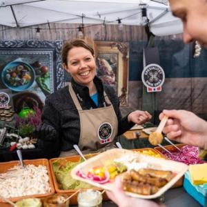 A man eating a serving of sausages at the Matstreif food festival in Oslo