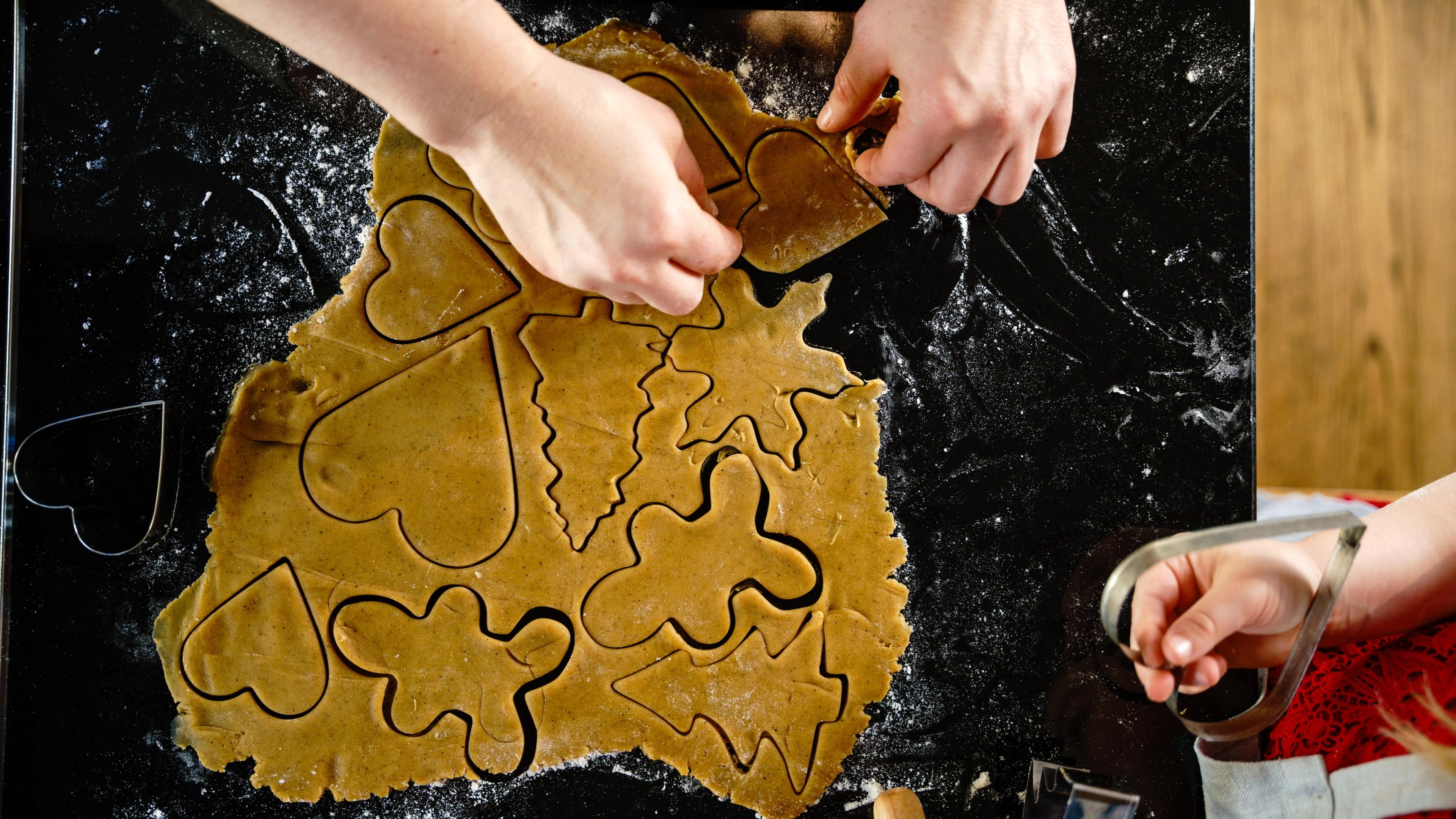 Rolled-out gingerbread dough with metal cookie cutters placed on top
