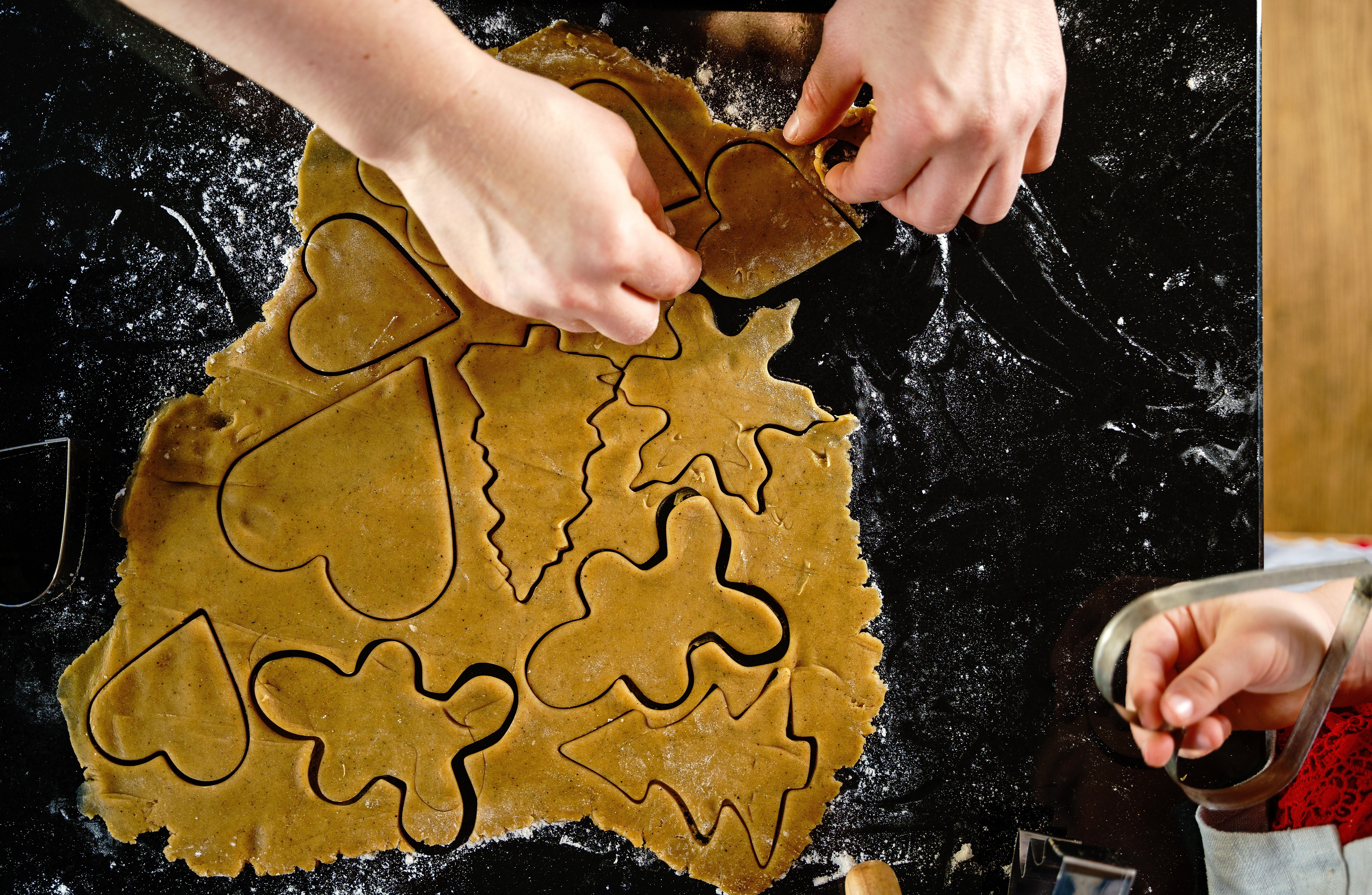 Rolled-out gingerbread dough with metal cookie cutters placed on top