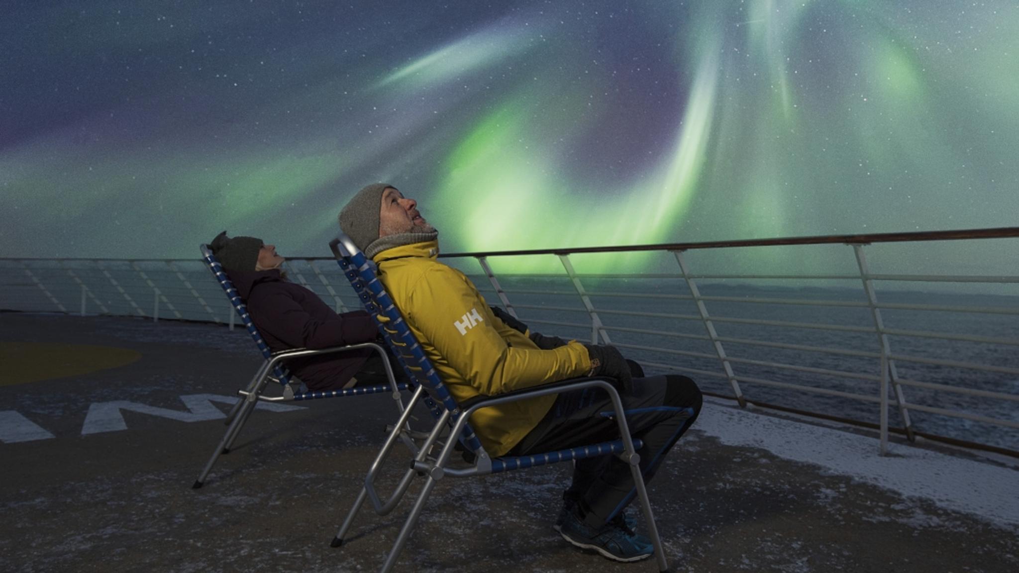 Two people watching the Northern Lights at the Hurtigruten