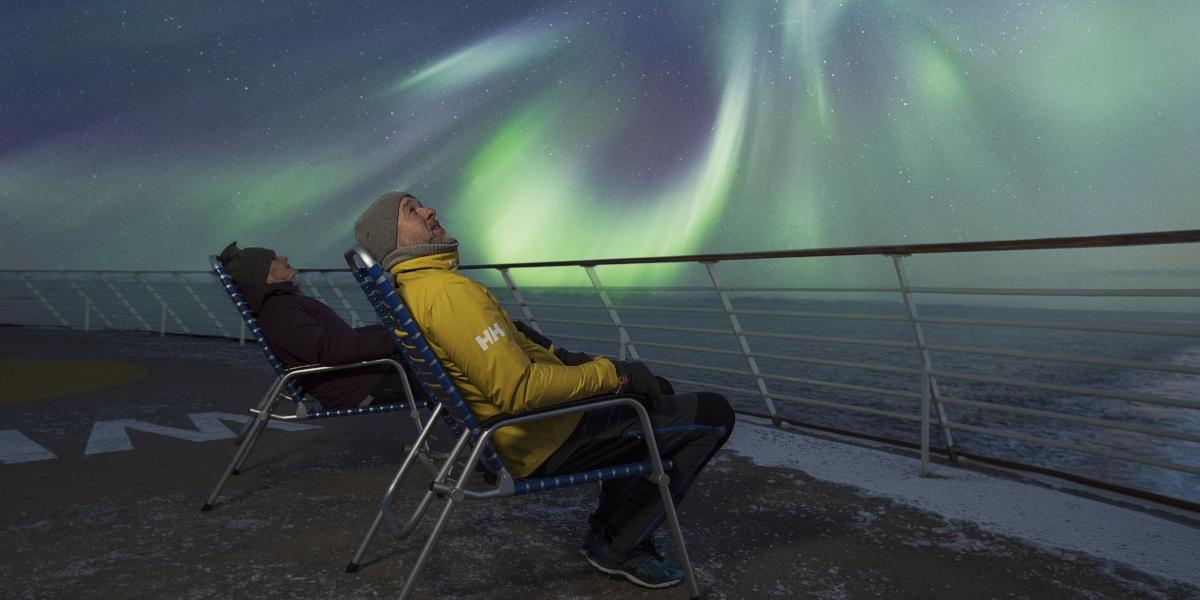 Two people watching the Northern Lights at the Hurtigruten