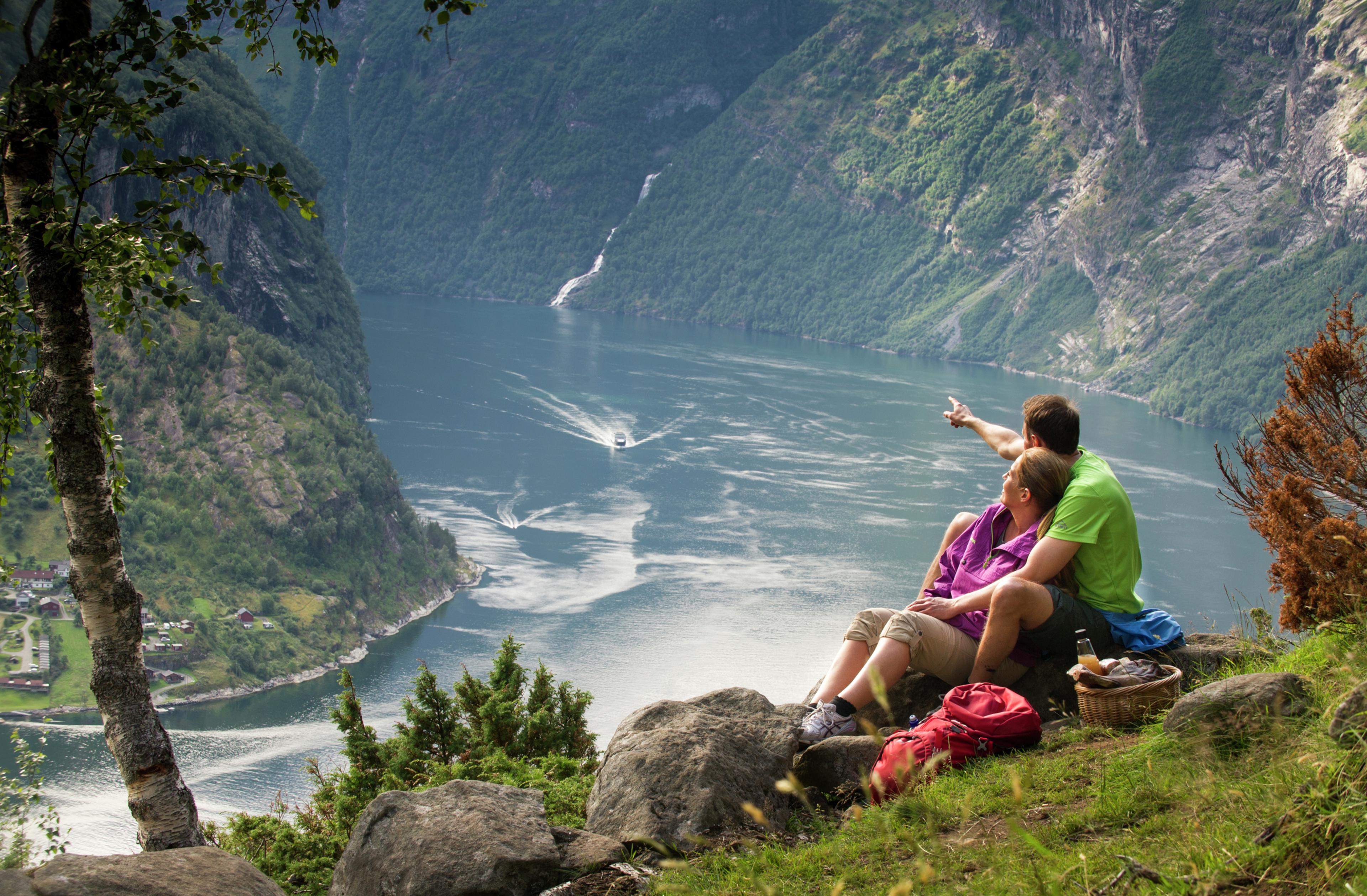 A couple having a picnic with a view in Geiranger, Fjord Norway