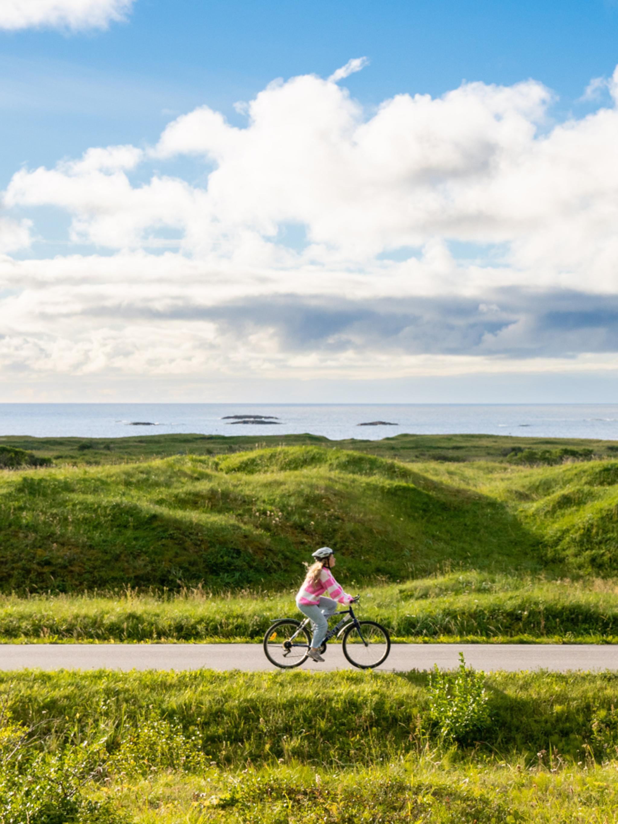 Woman biking the Norwegian Scenic Route at Andøya