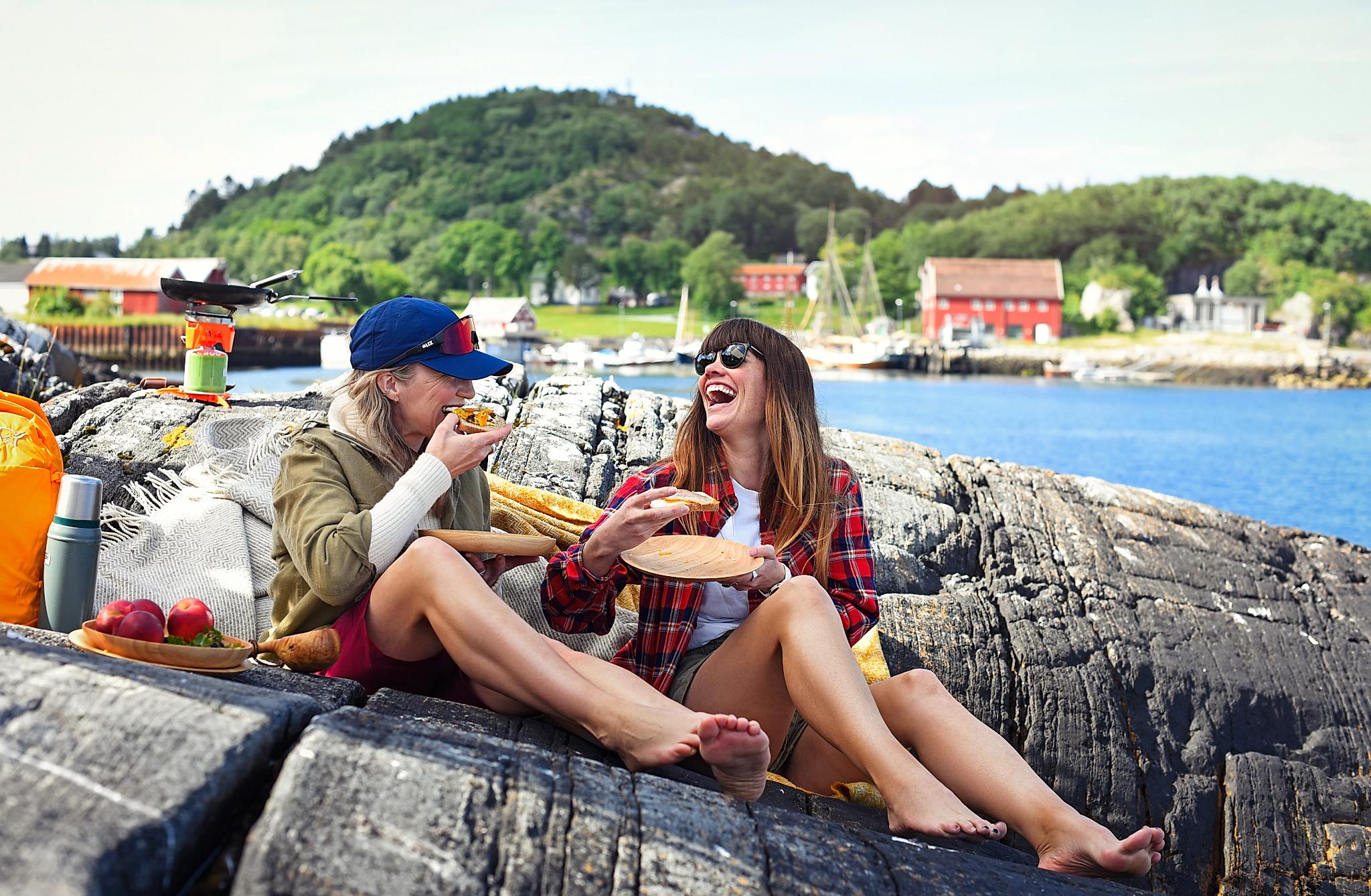 Two women sharing a meal at an archipelago by the sea in the Trøndelag area, Northern Norway