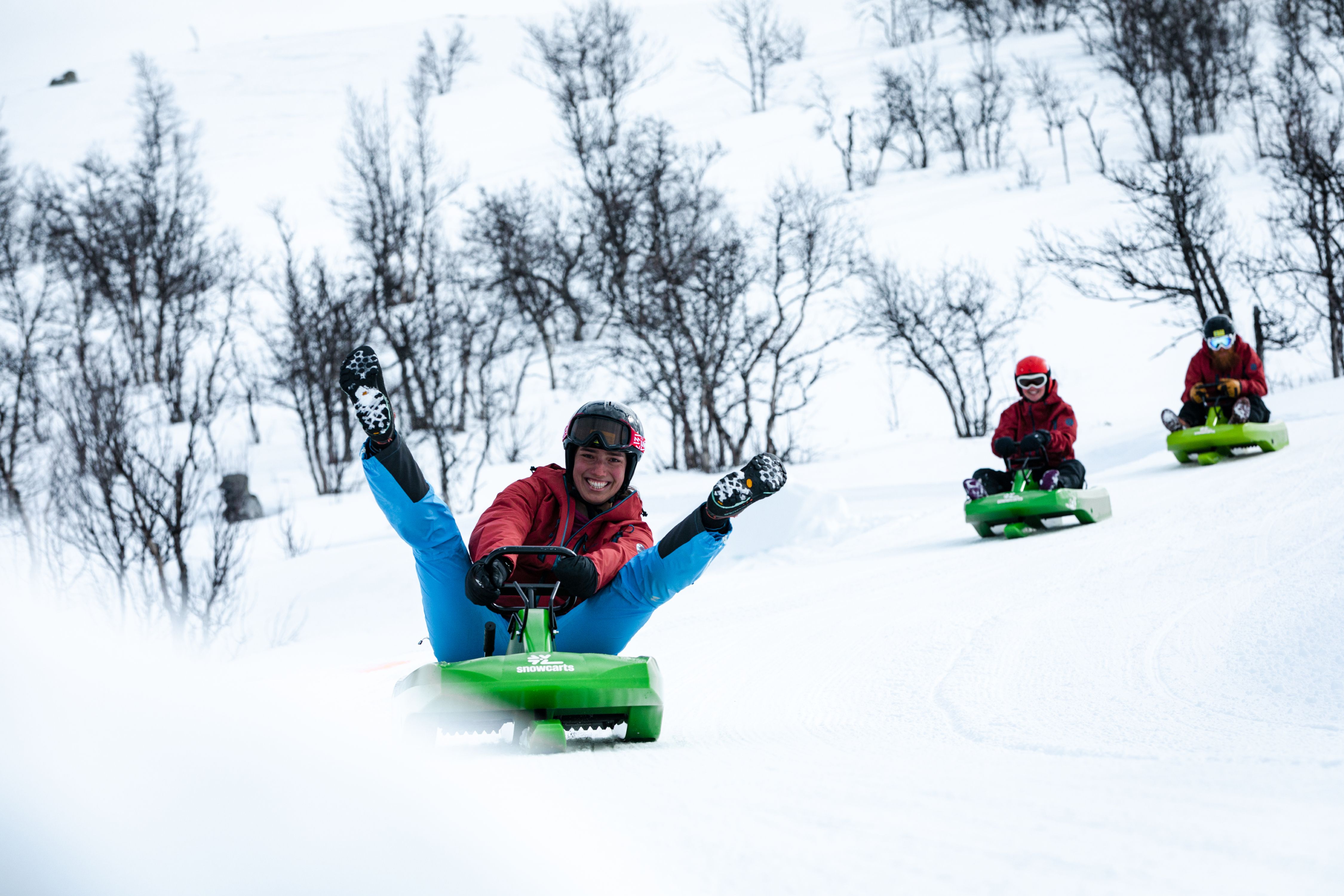 Three people sledging down the toboggan run in Dagali fjellpark in Geilo, Eastern Norway