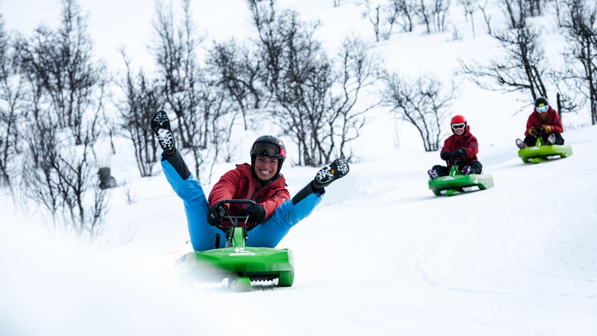 Three people sledging down the toboggan run in Dagali fjellpark in Geilo, Eastern Norway