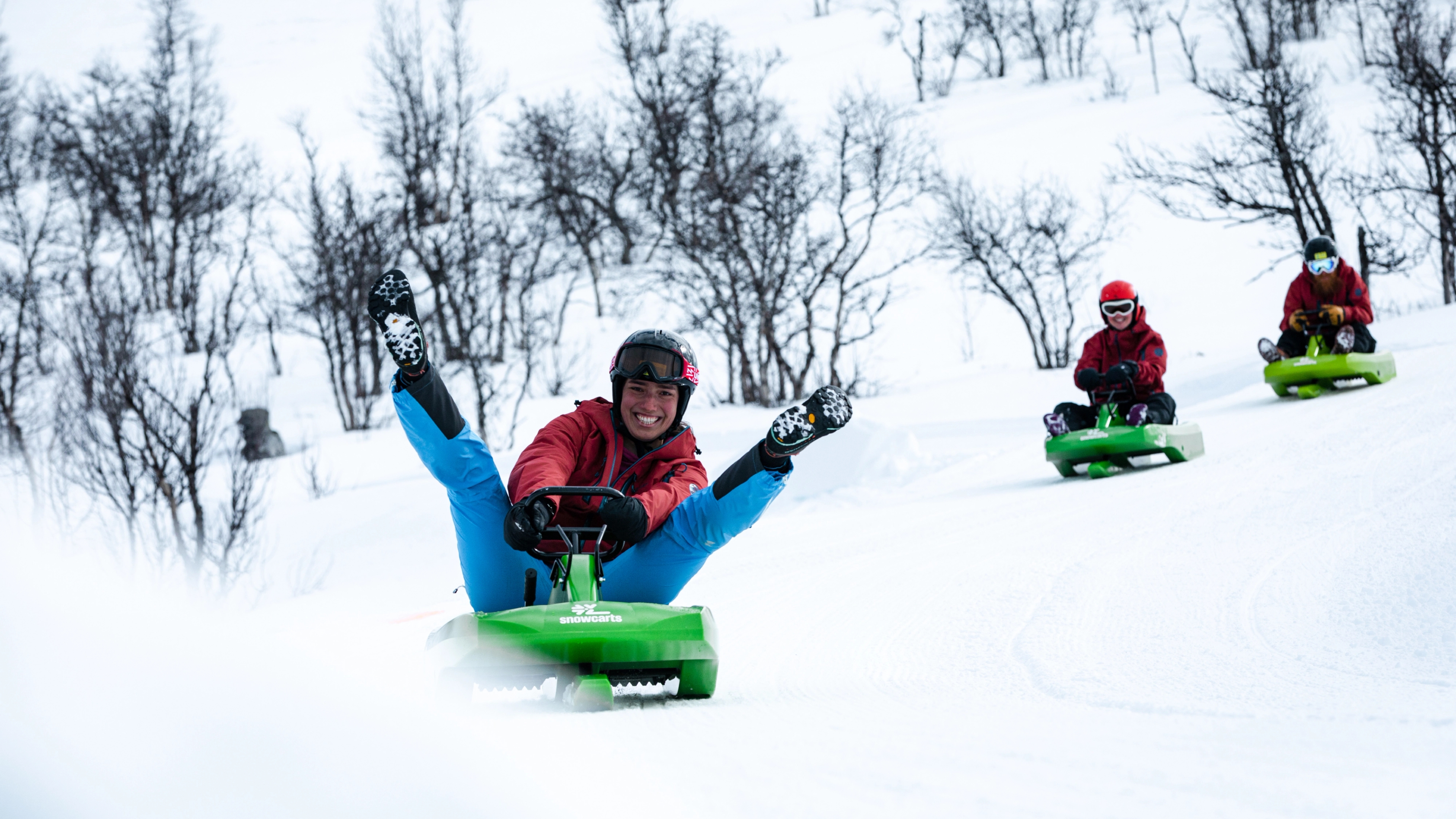 Three people sledging down the toboggan run in Dagali fjellpark in Geilo, Eastern Norway