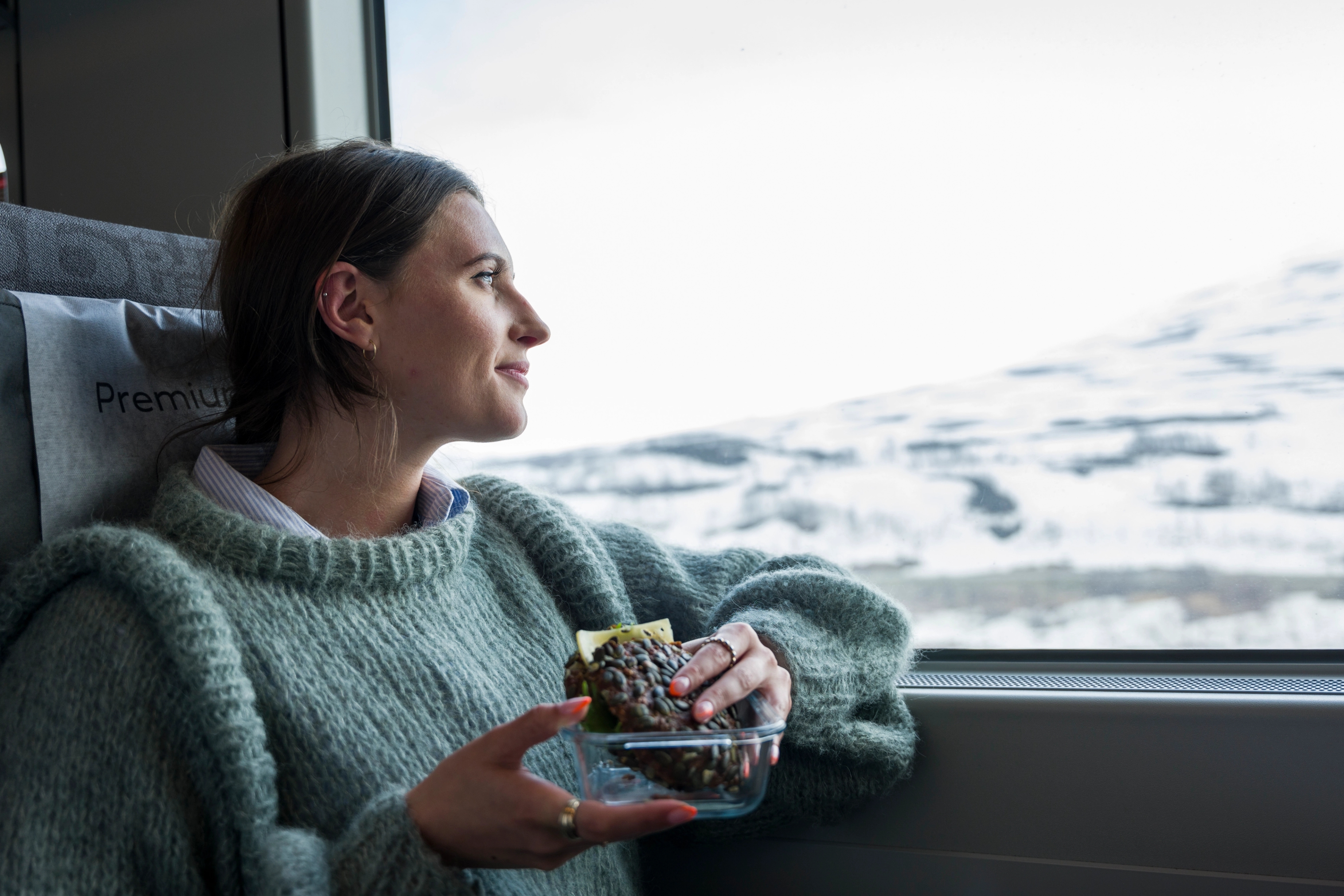 Woman taking in the view of snowy mountains on the train