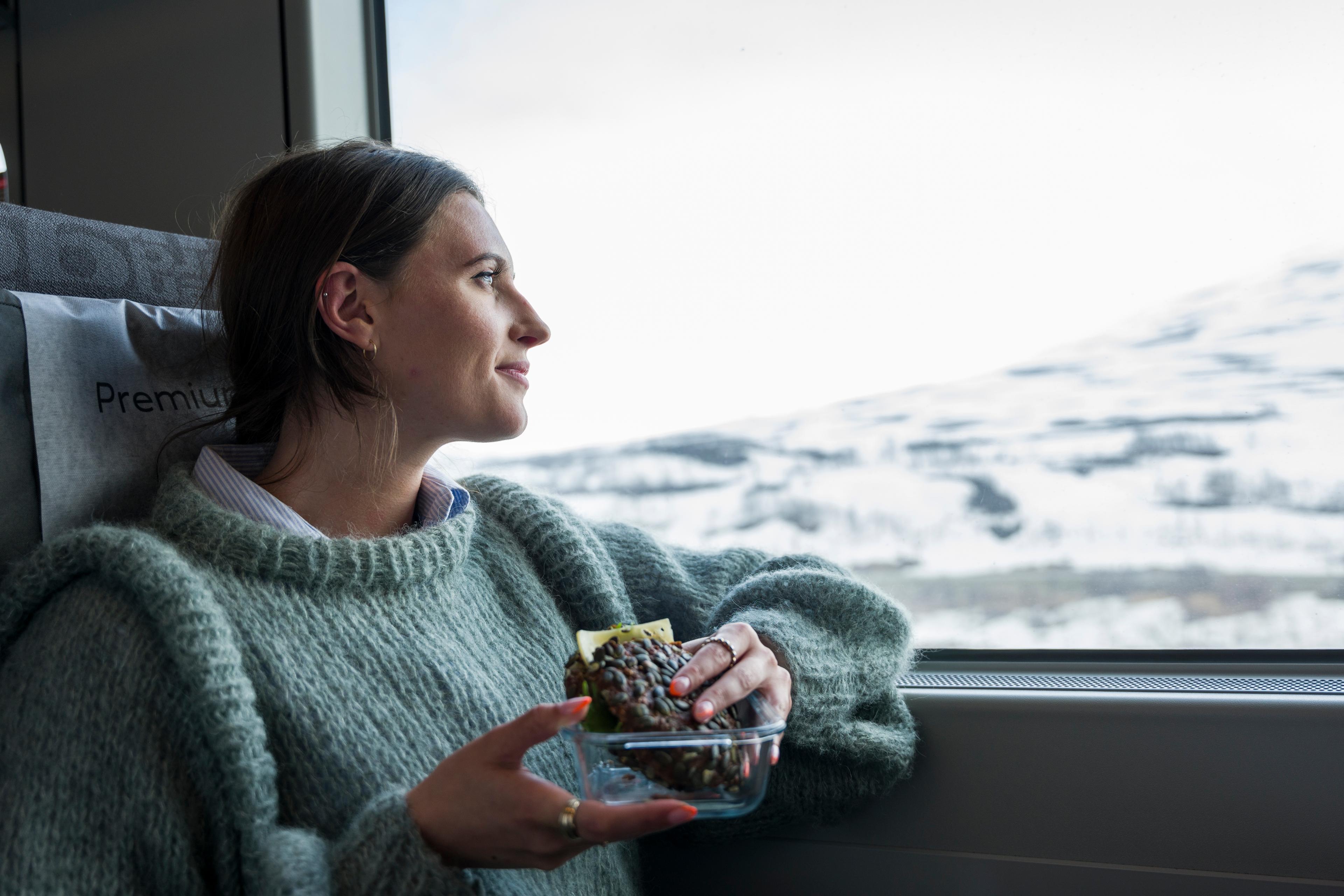 Woman taking in the view of snowy mountains on the train