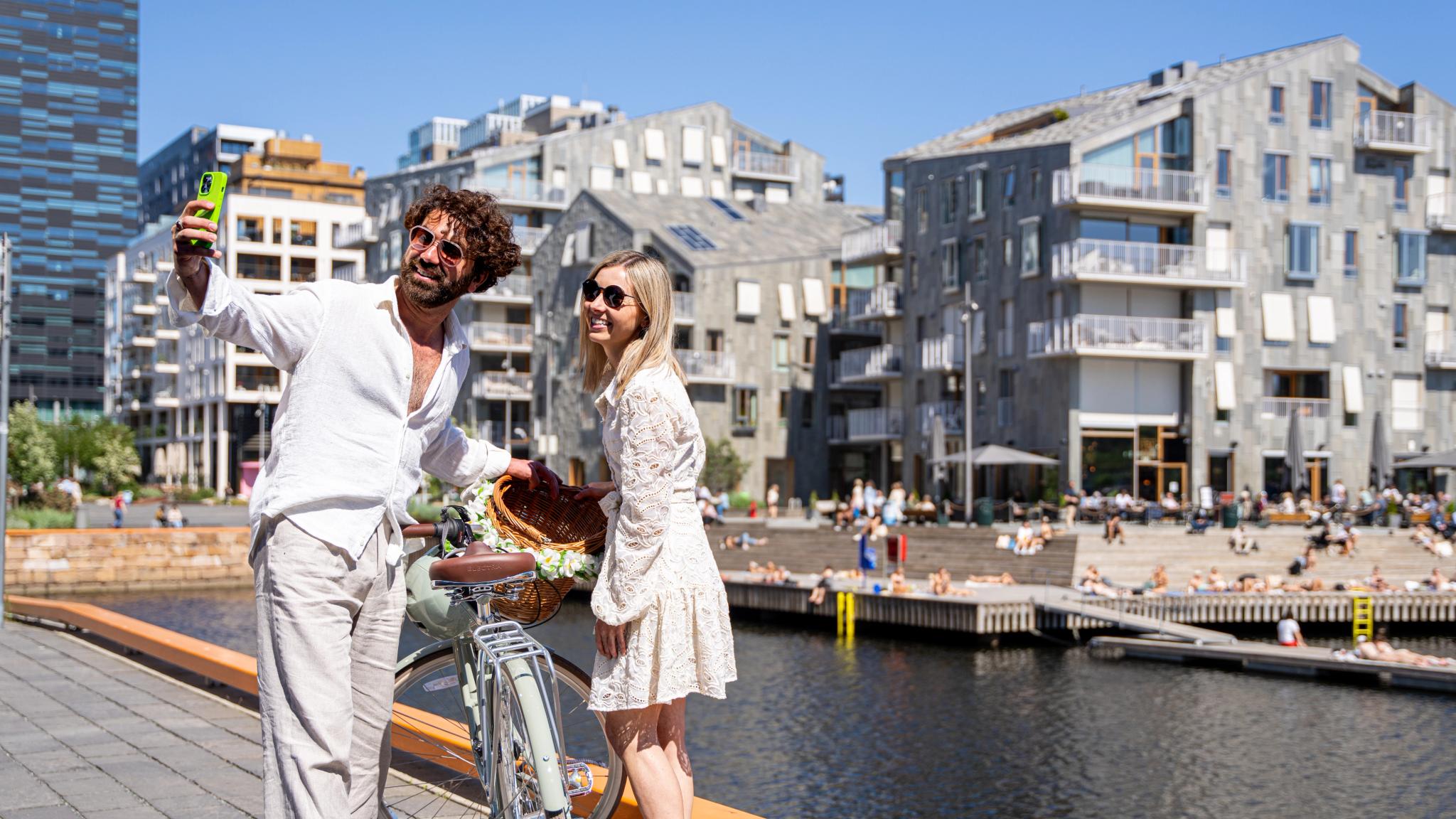 A couple in front of a wharf in Oslo