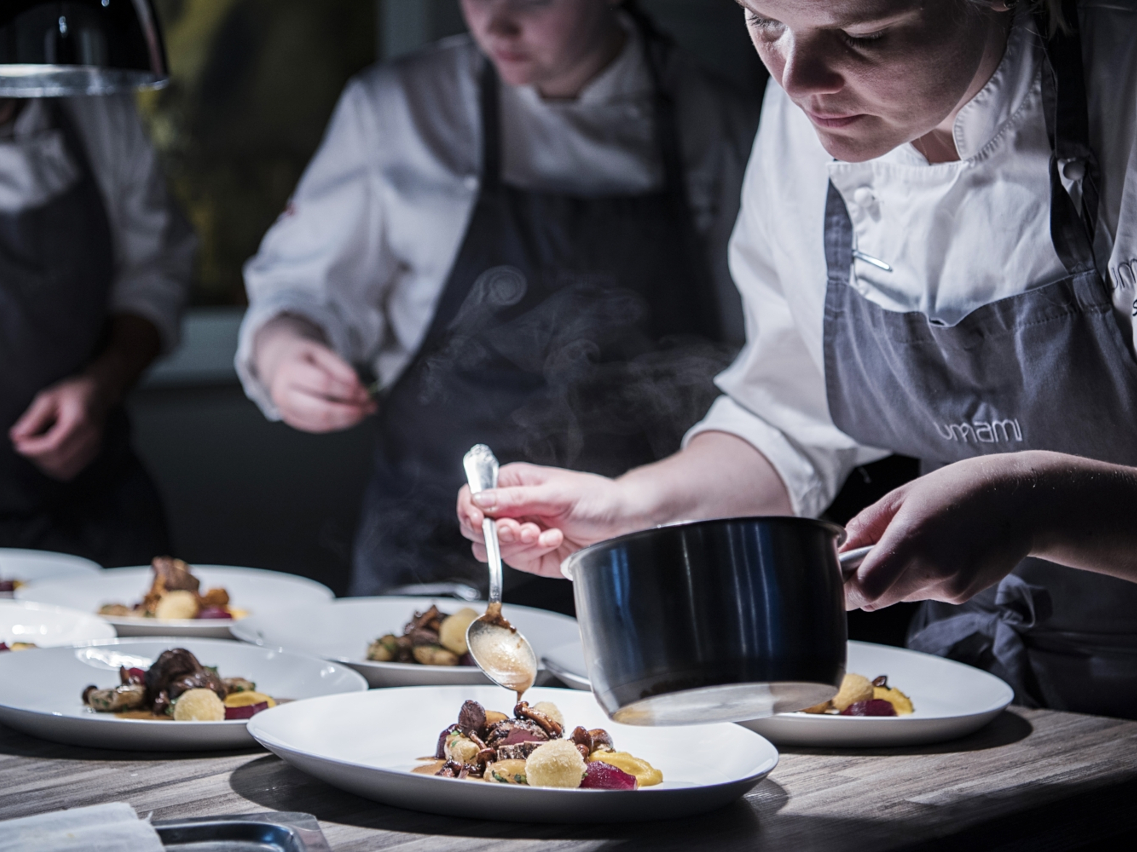 Chefs garnishing raw tastes of autumn in the kitchen at the Umami restaurant in Harstad, Norway