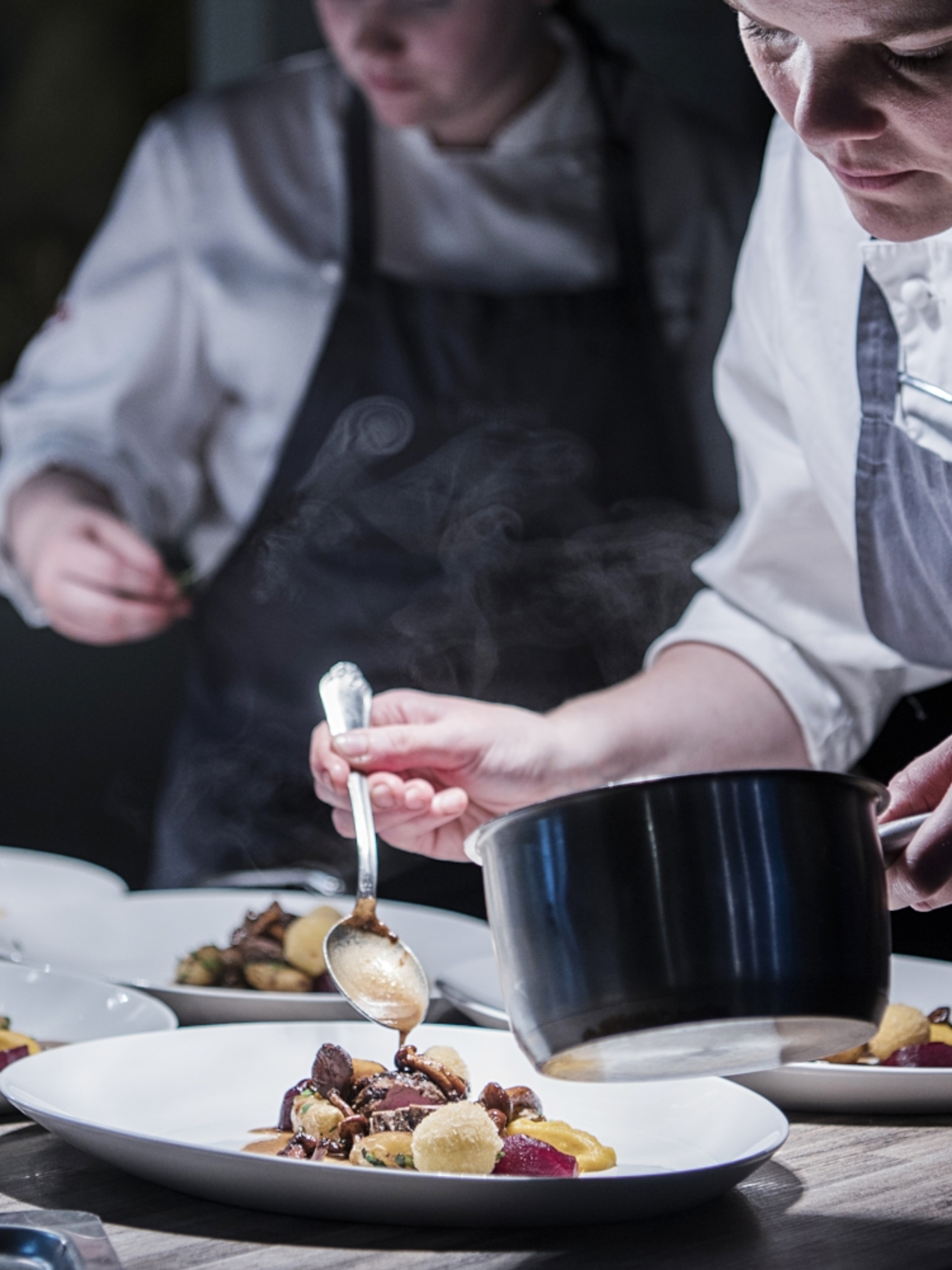Chefs garnishing raw tastes of autumn in the kitchen at the Umami restaurant in Harstad, Norway
