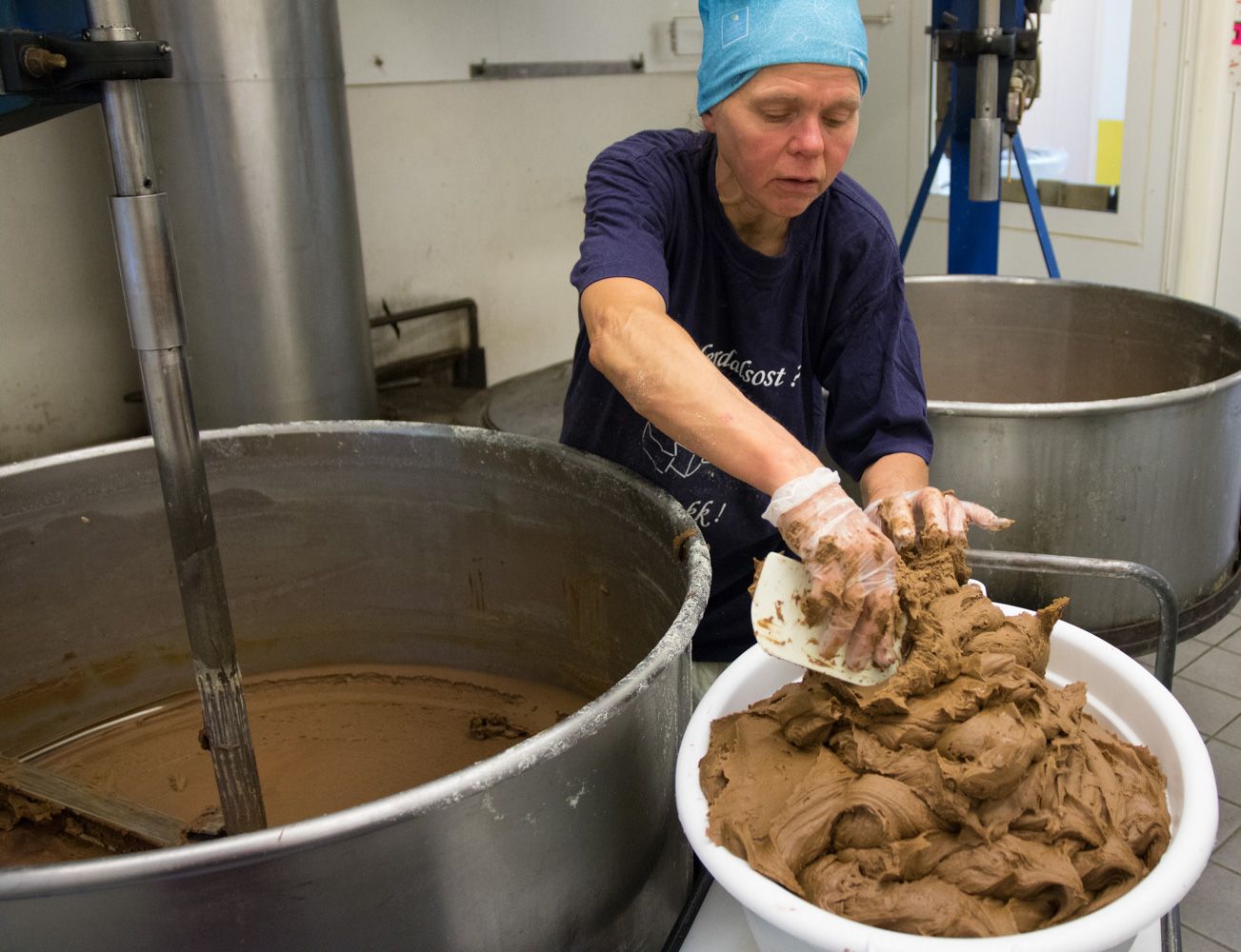 Woman making brown cheese at the cheese factory Undredal Stølsysteri in Aurland in the Sognefjord region of Fjord Norway