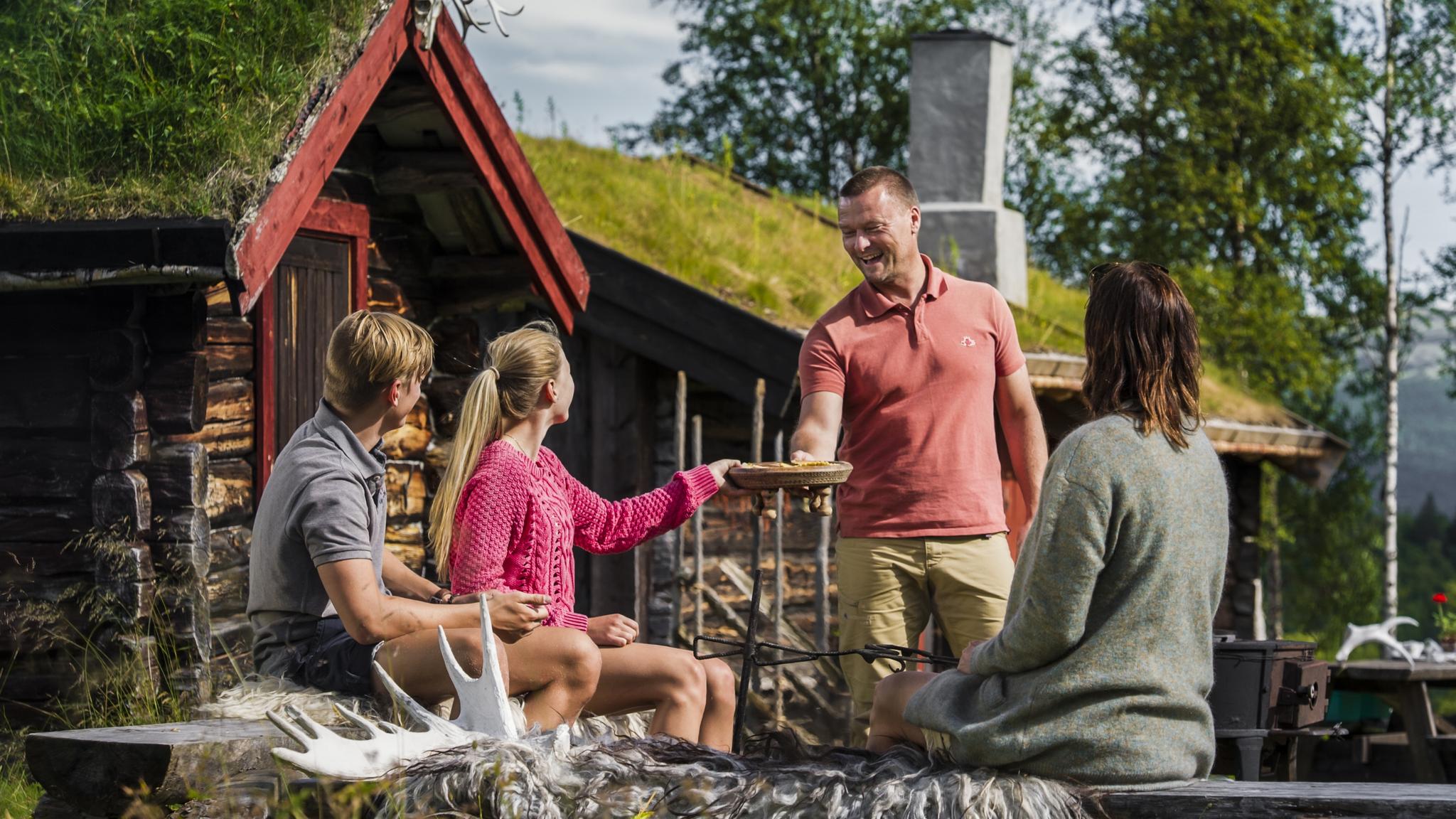 Four people eating outside of Utistuvollen Seterkafe in Vingelen