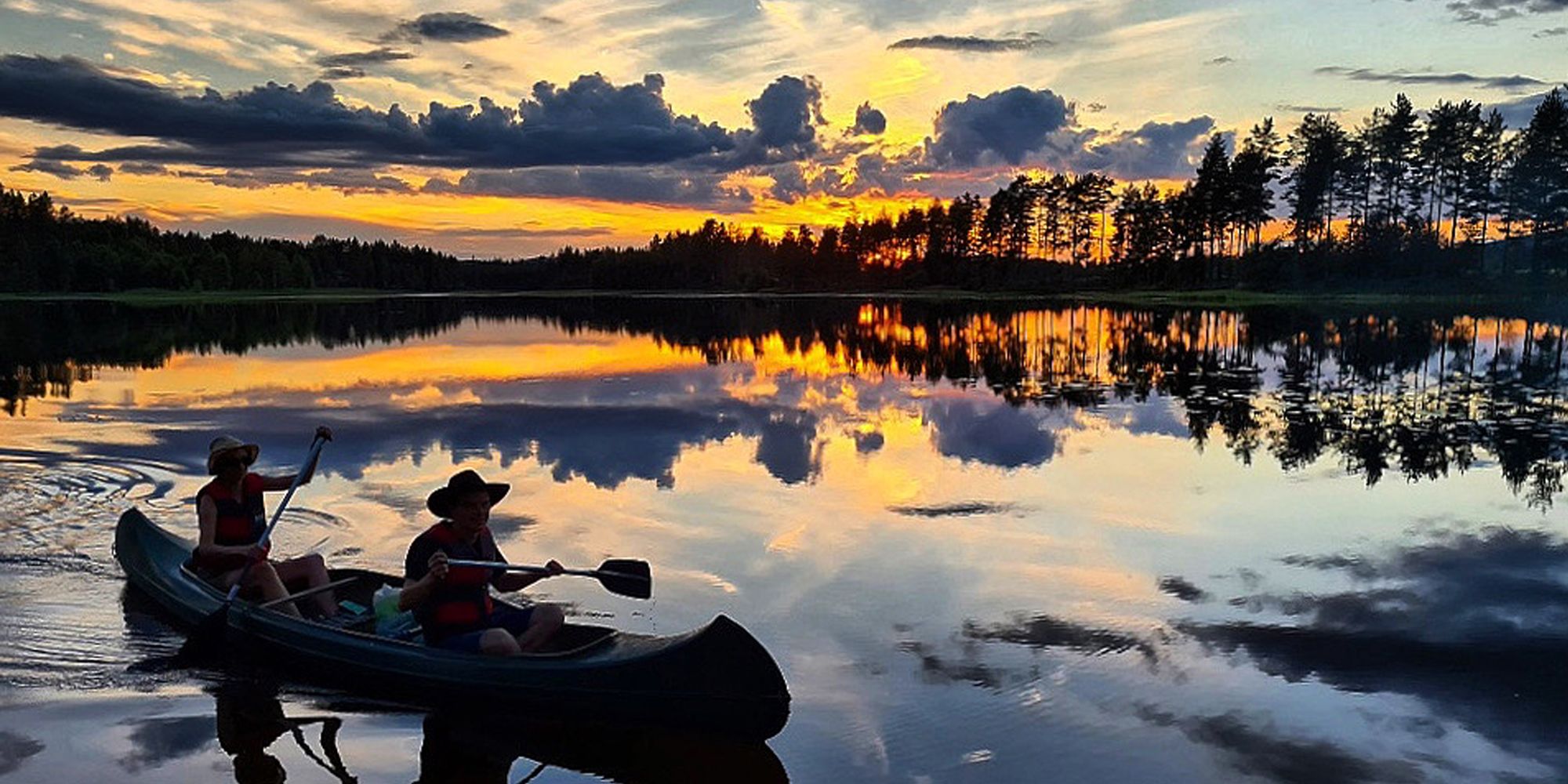 Two people canoeing in the sunset in Eastern Norway