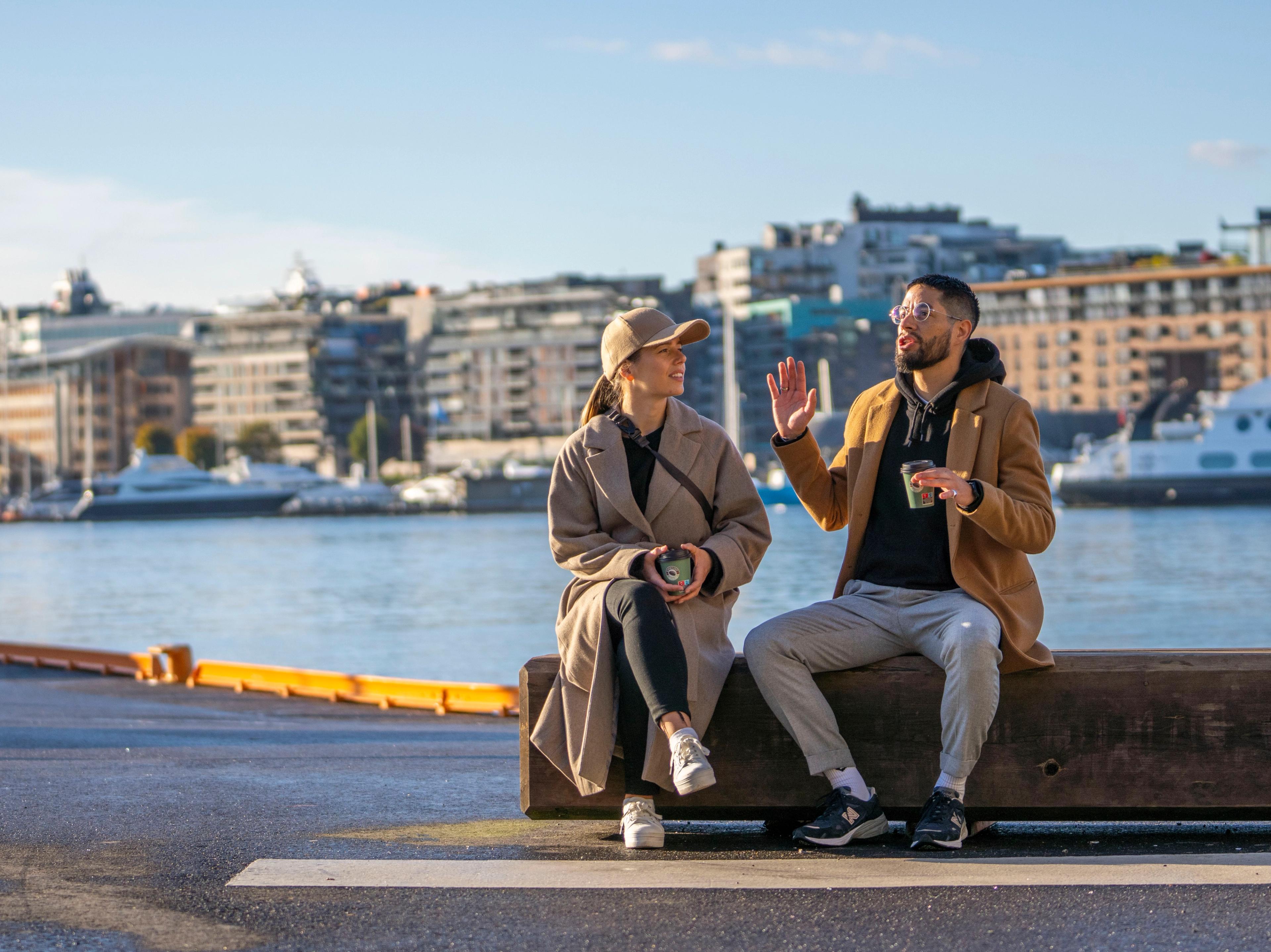 Two friends sitting at Festningskaia in Oslo, Norway