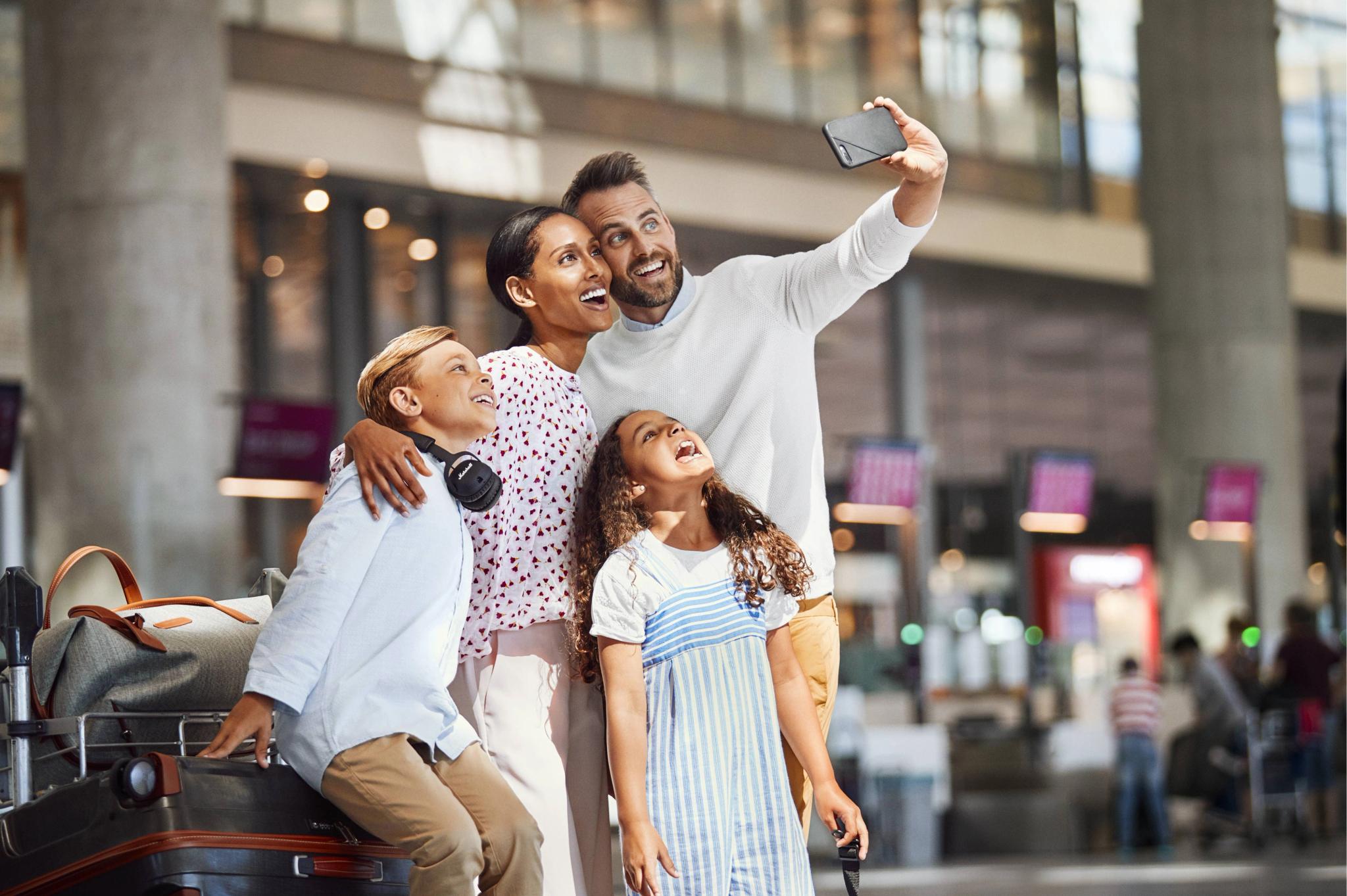 Happy family taking a selfie in an airport after arriving to Norway