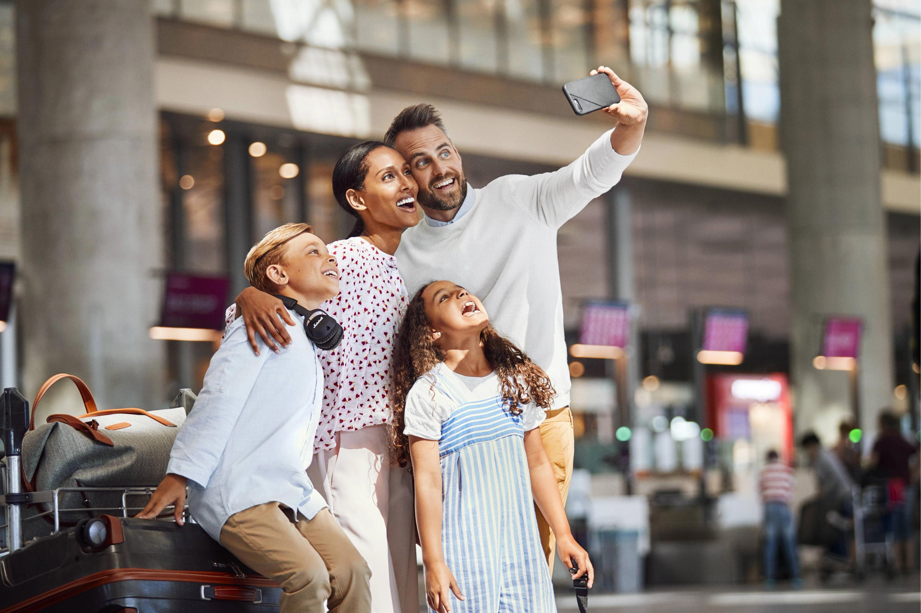Happy family taking a selfie in an airport after arriving to Norway