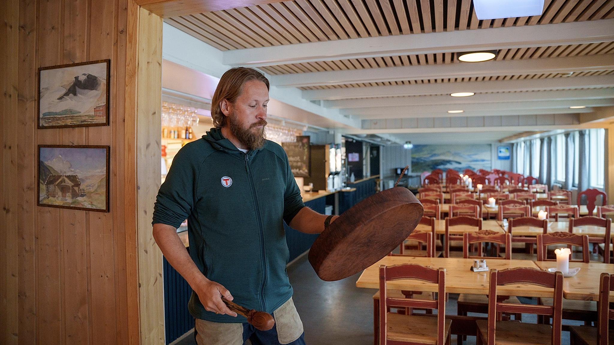 A man holding a drum inside a mountain lodge