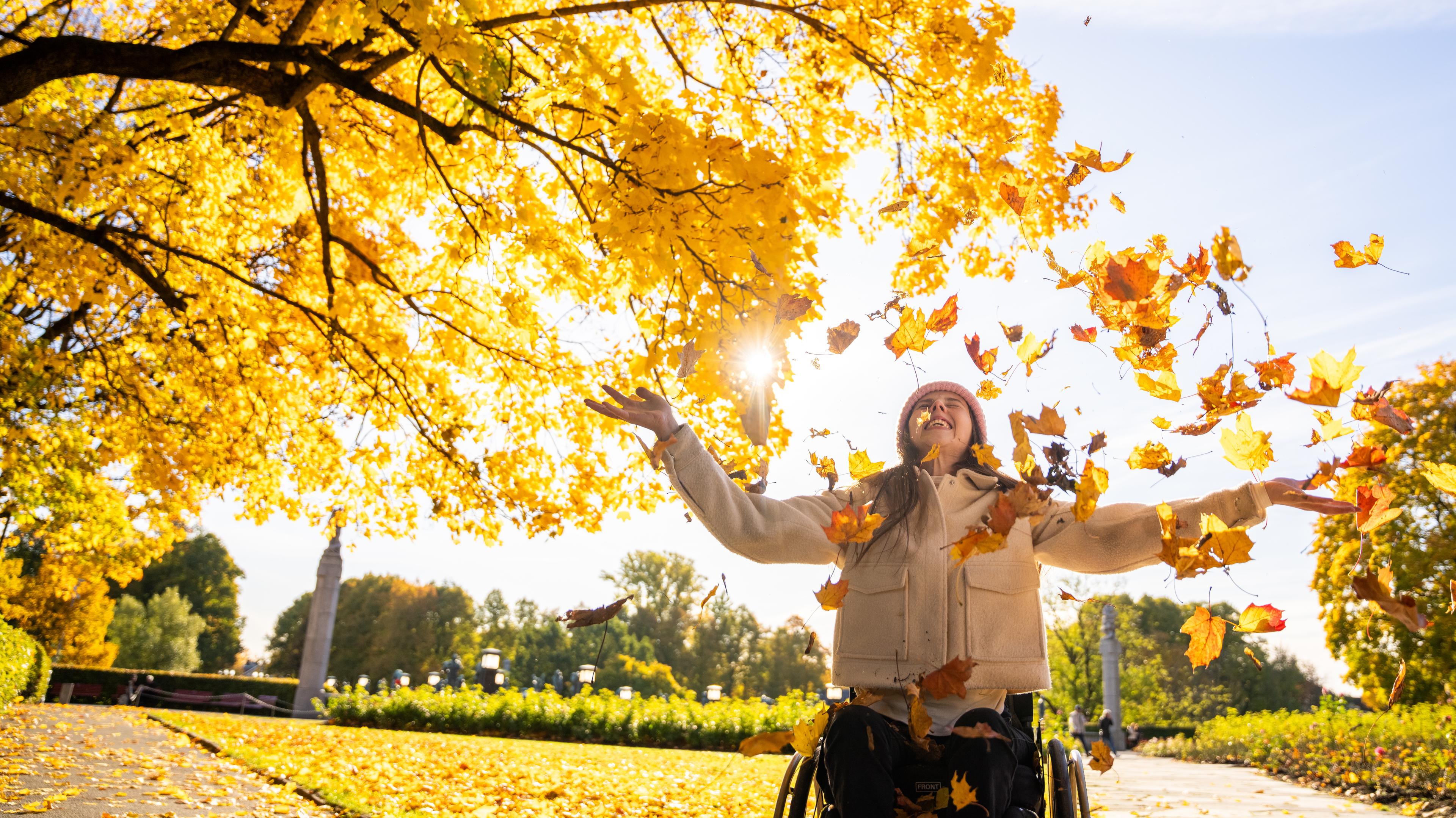 Girl throws leaves in Vigelandsparken in Oslo, Eastern Norway
